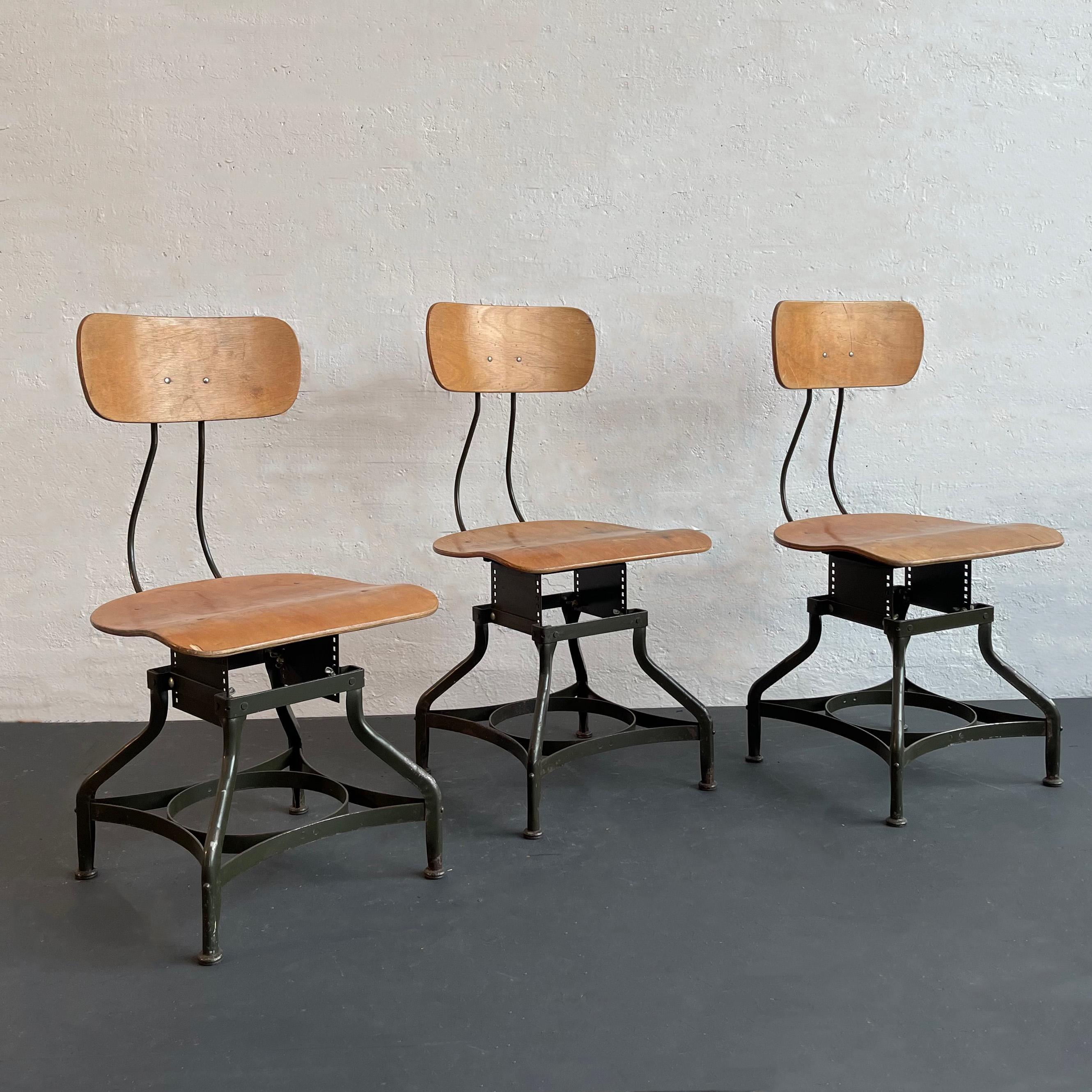 Cet ensemble de trois chaises d'atelier industrielles et réglables de Toledo Metal Furniture Co. présente les bases en acier peintes en étoile de Toledo avec des sièges et des dossiers en érable courbé. La hauteur des chaises est réglable de 13 à 16