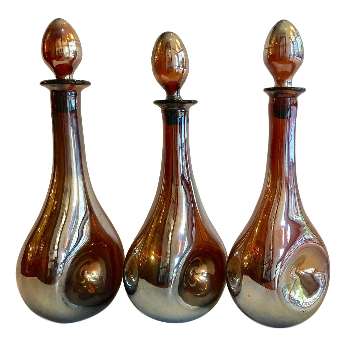 Un ensemble de trois décanteurs en verre irisé français des années 1940 avec bouchons. Vendu à l'unité.

Mesures :
Hauteur 17