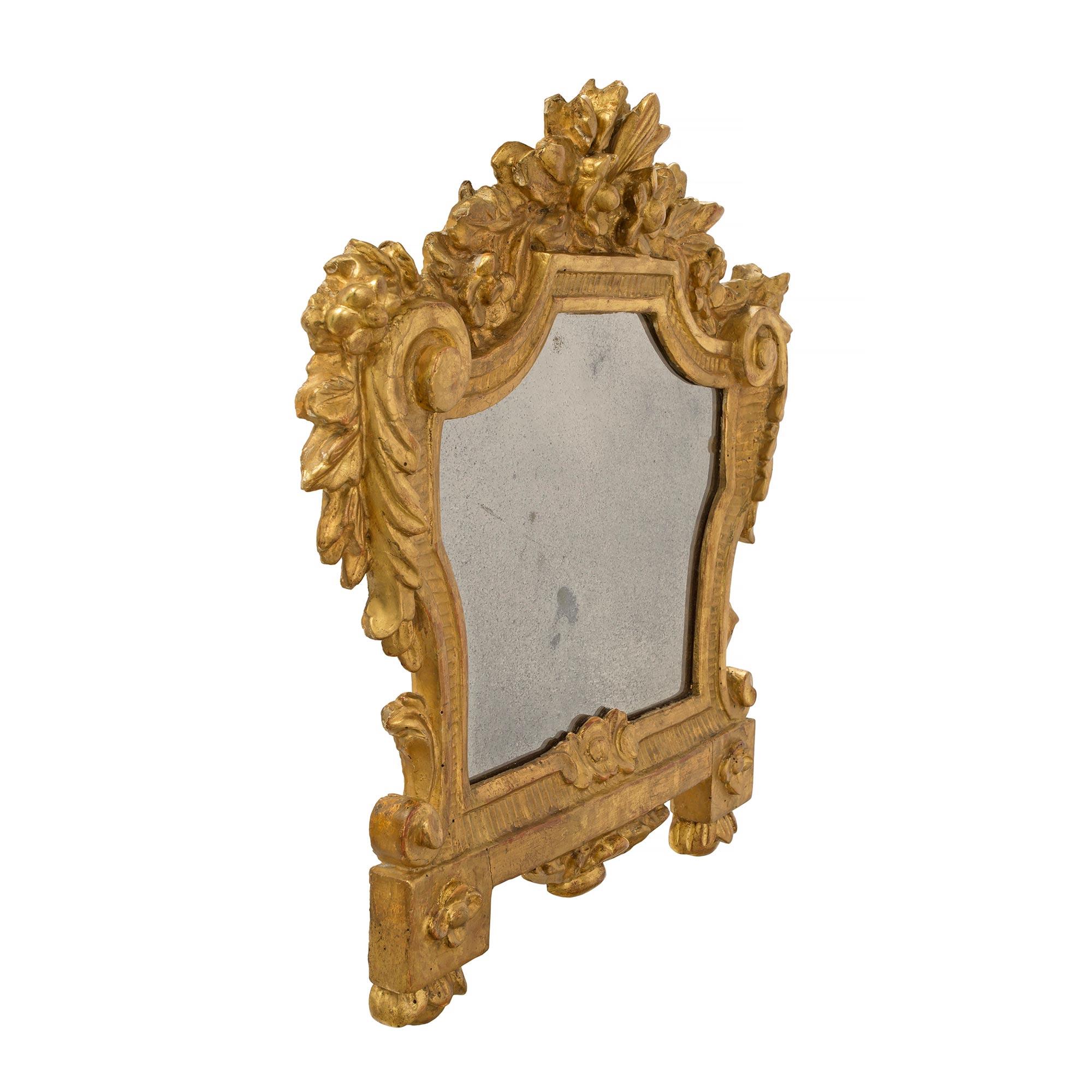 A charming and complete set of three Italian 18th century Louis XV period giltwood mirrors. The mirrors are raised by protruding block supports with detailed rosettes and foliate designs. Each mirror plate is bordered by reeded foliate designs and S