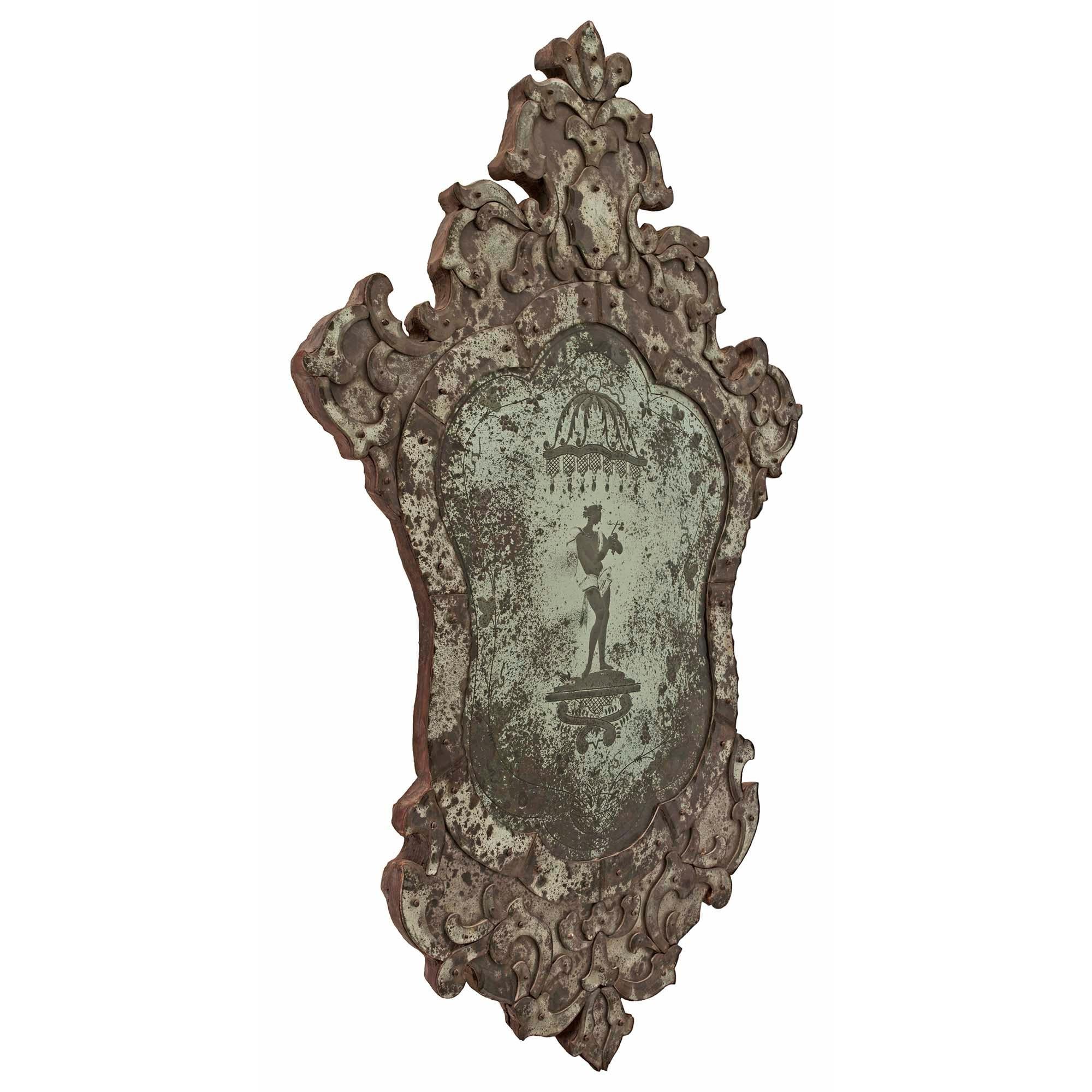 A set of three stunning Italian early 19th century Venetian etched mirrors. The wonderful mirrors have a unique shape with scrolls and foliate frames and an elegant top crown. Each mirror has a central etching of classic roman figures amidst scrolls