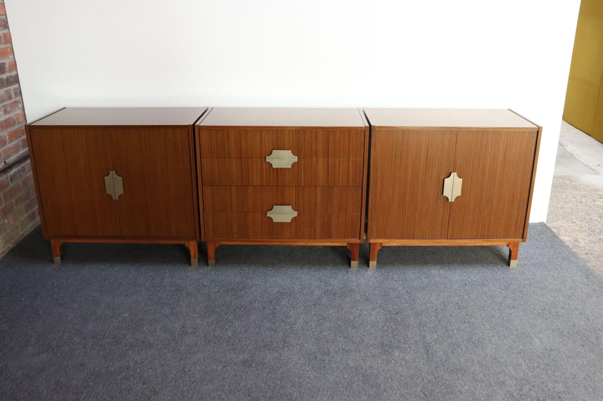 Set di tre piccoli comò/comodini in mogano (due armadietti e una cassettiera) che possono essere esposti insieme per essere utilizzati come credenza o credenza, con tiretti e sciabole in alluminio anodizzato altamente stilizzato di Longato