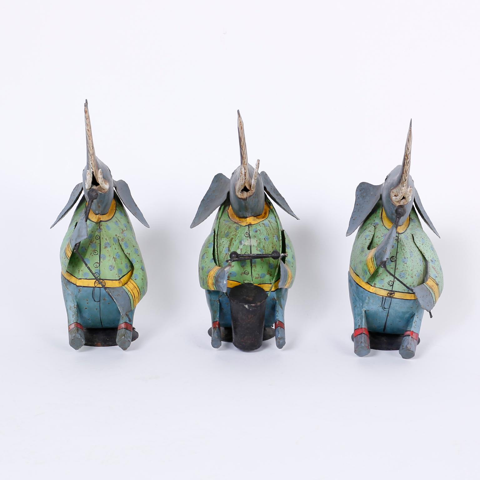 Strike up the band with three amusing, folky painted metal elephants singing and drumming in gay attire with a rustic oxidized finish.