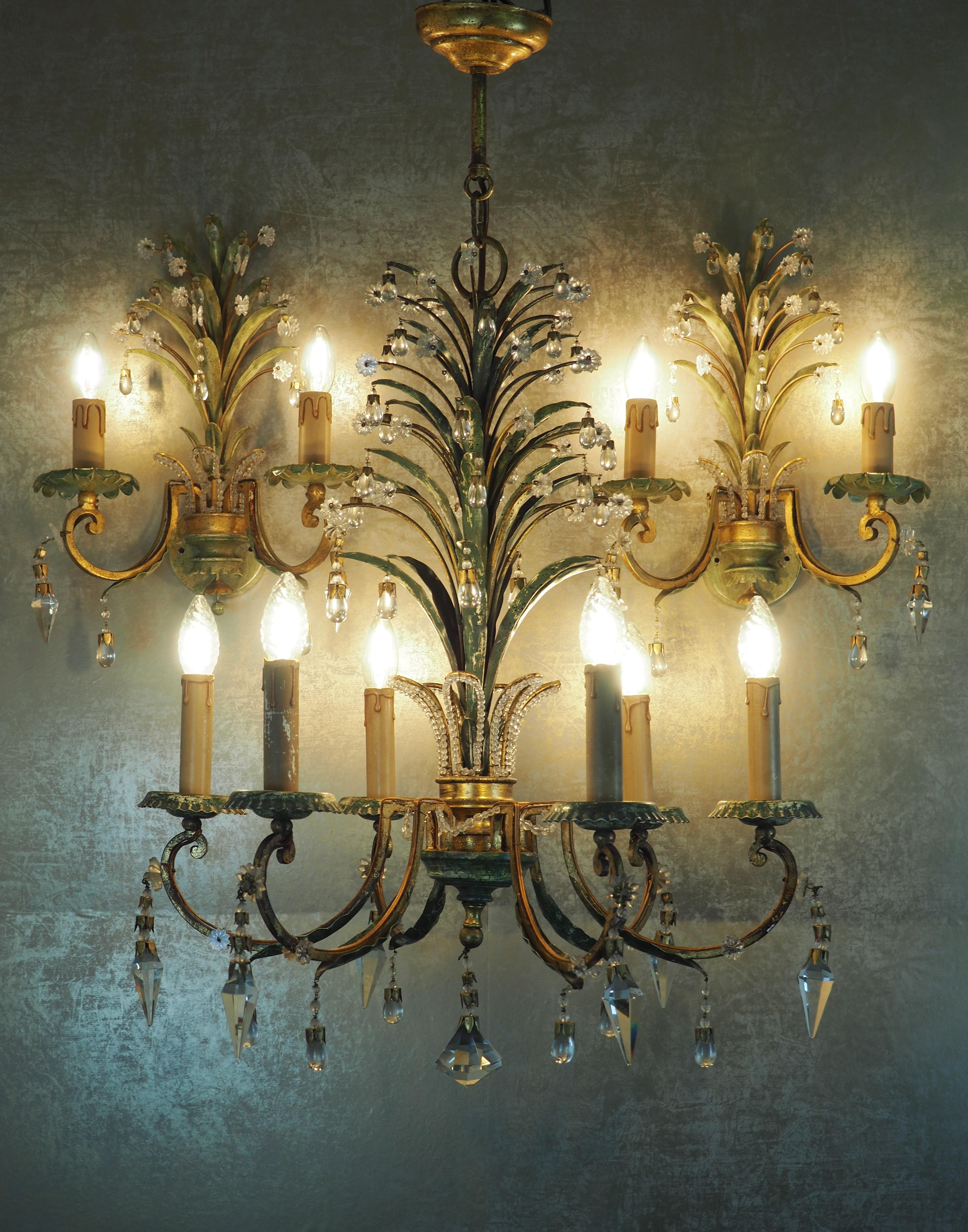 A wonderful set of three pineapple light fixtures by G. Banci, Italy, circa 1970s.
This beautiful handcrafted chandelier and sconces are made of patinated and gilt iron, decorated with lead crystals tear drops and prism.
Socket: e 14 for standard
