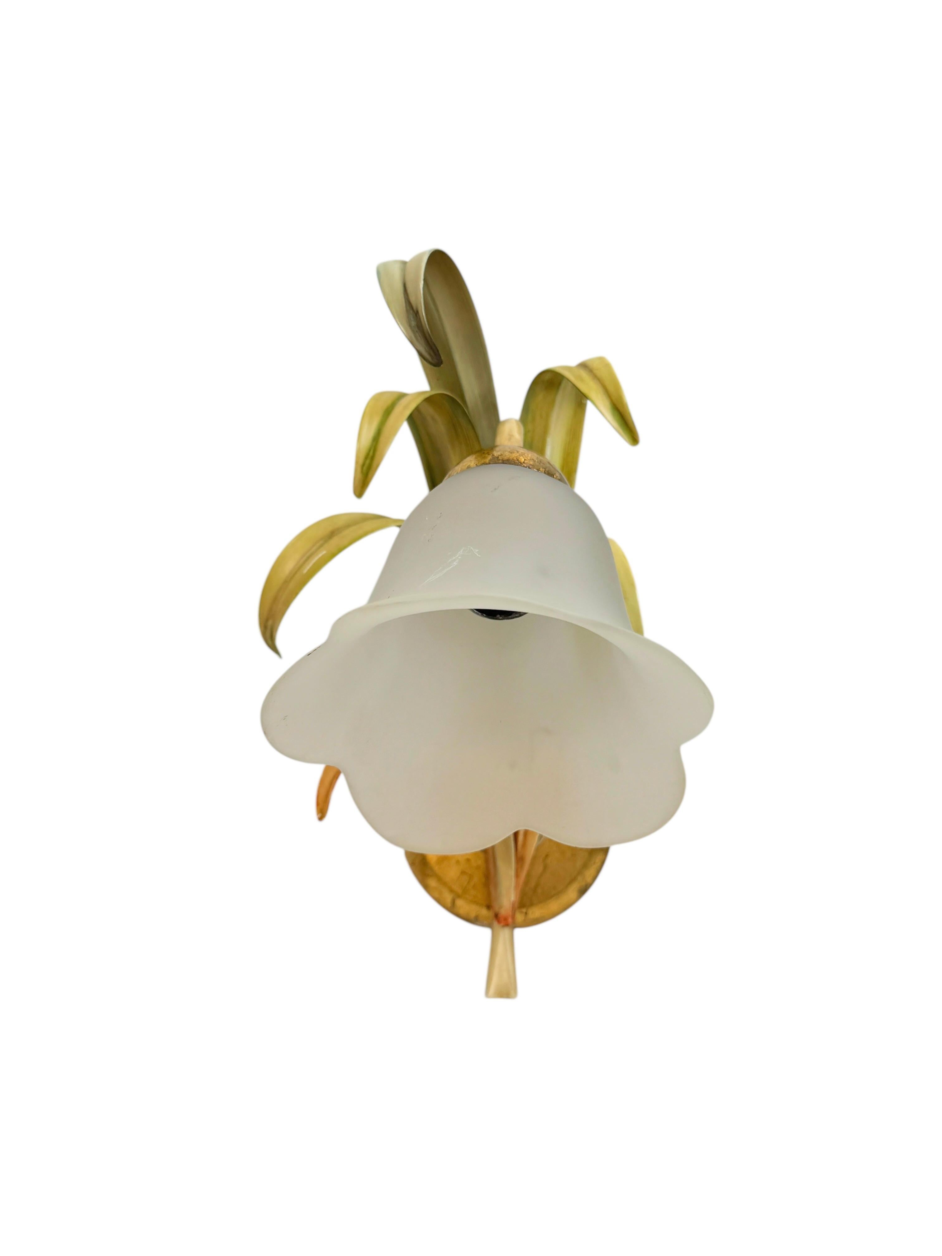 A set of three metal and glass floral sconce. Each fixture requires an European E14 candelabra bulb, up to 40 watts. The wall light has a beautiful color and gives each room an eclectic statement. Light bulbs are not included in this offer. Found at