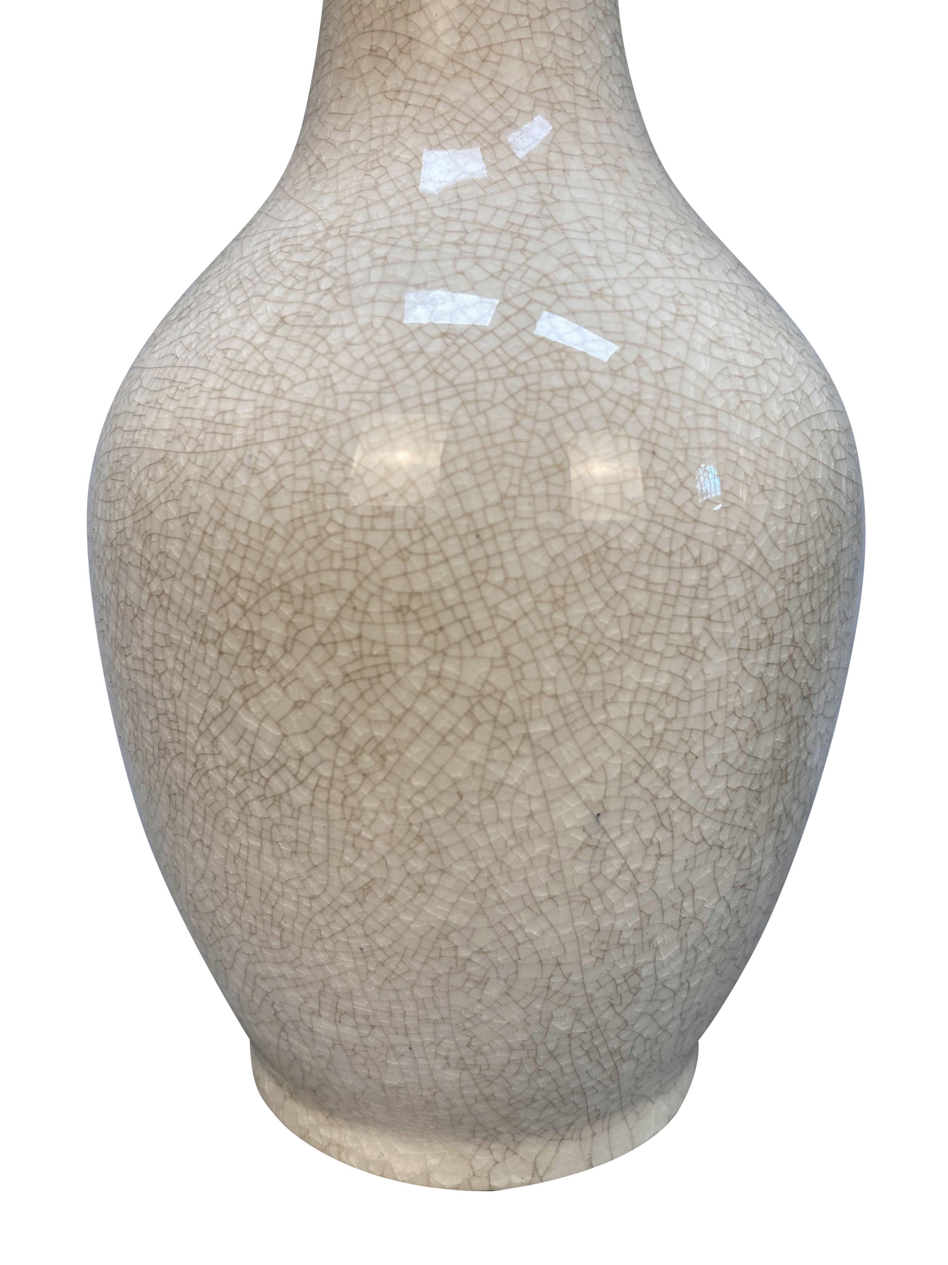 A set of three Japanese vases, comprising a celadon vase with Greek key design around the collar c.1900, an emerald green cloisonne, silver-mounted vase c.1930 and a cream crackle glazed vase, c.1930.
Measures: 31cm high x 15cm diameter (largest)