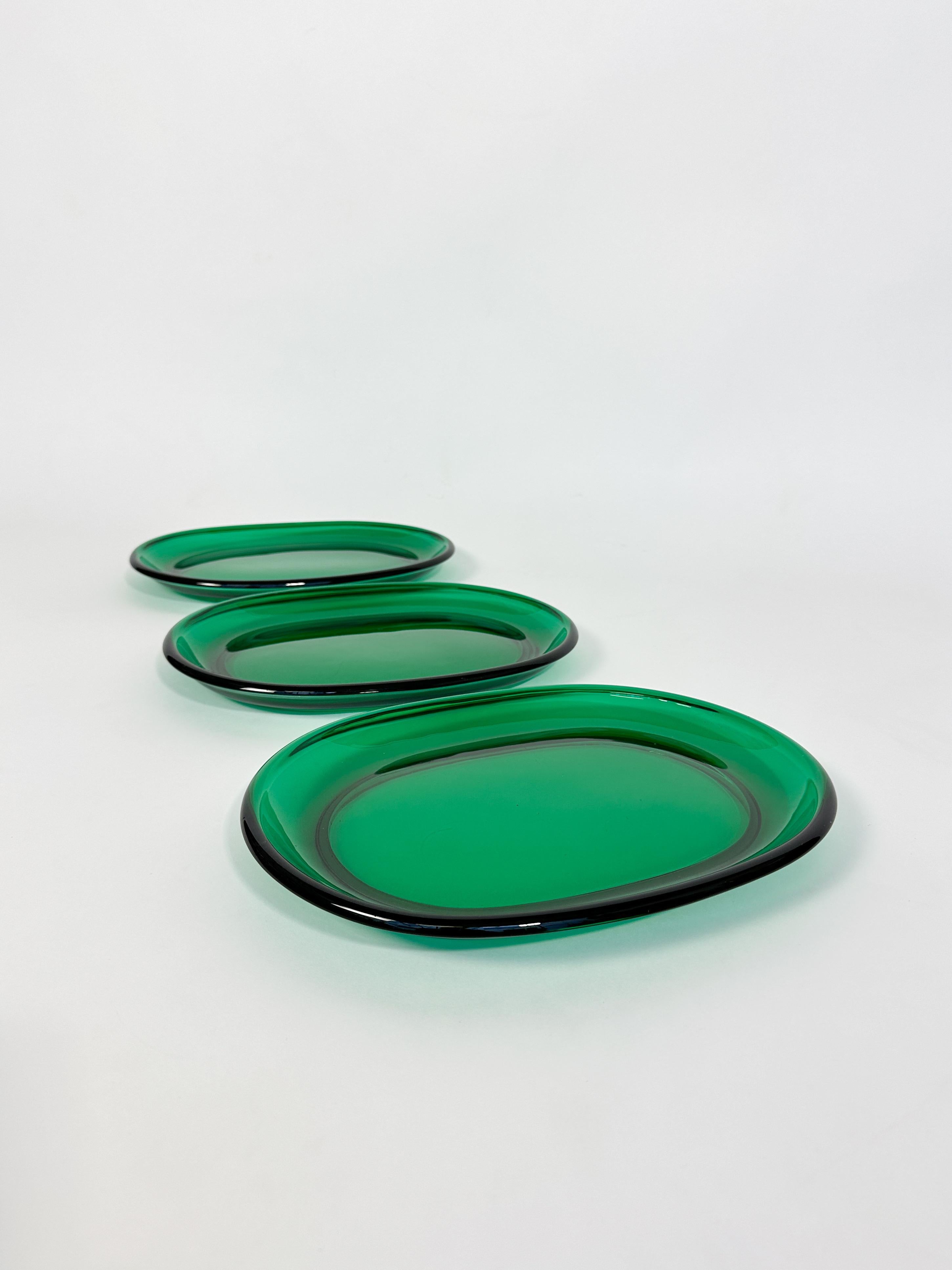 Set of three Josef Frank lobster plates in a vibrant green glass, hand-crafted by Reijmyre glass factory in Sweden, 1960s.

Good condition with signs of use and age. One of the plates has two chips on the foot ring, some more microchips along the