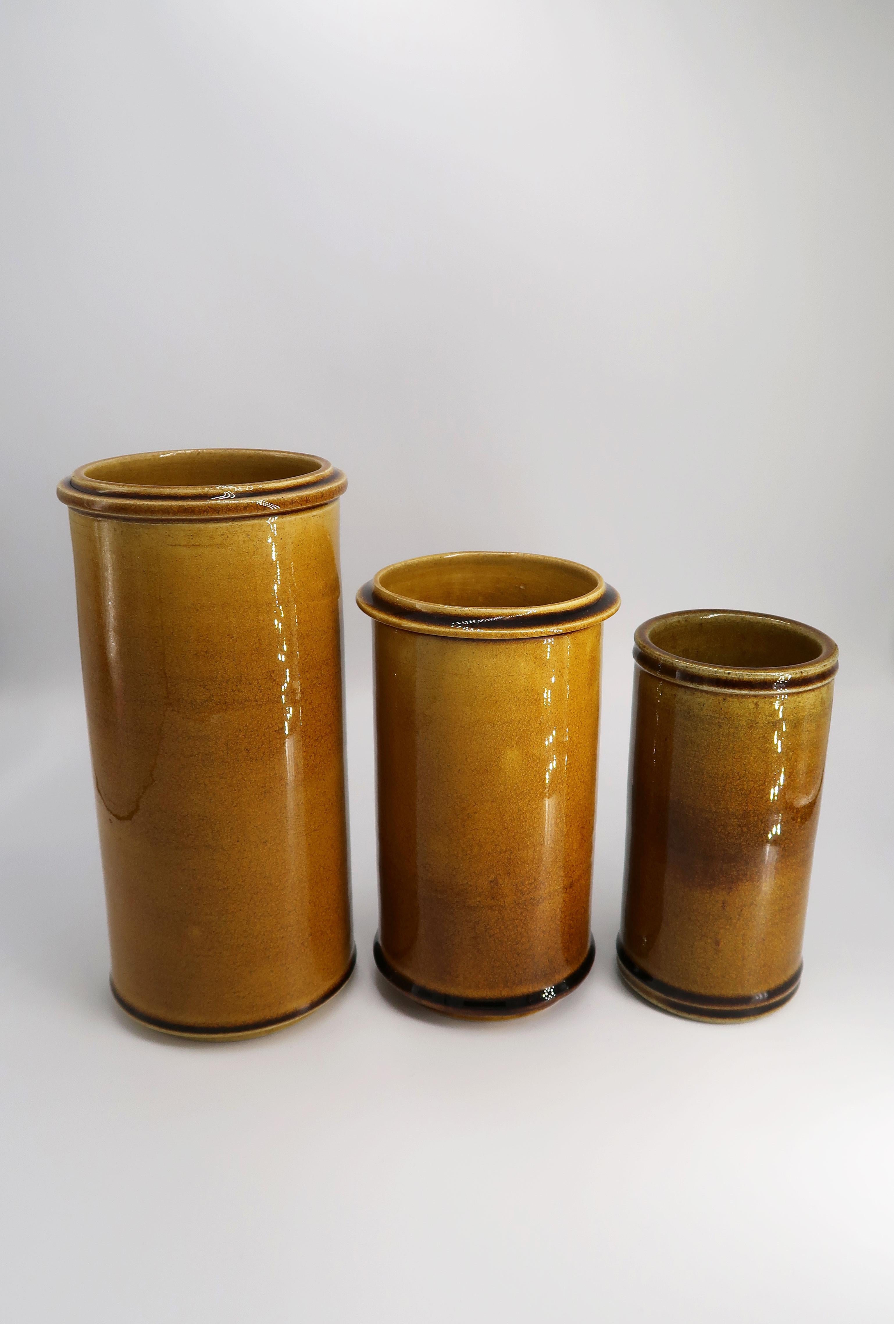 Stunning set of three Danish Mid-Century Modern handmade cylinder shaped 1950s vases by Herman Kähler. Manufactured in the town of Naestved in southern Zealand. Warm ochre colored crackle glaze applied by hand. Signed and stamped under base. Unused