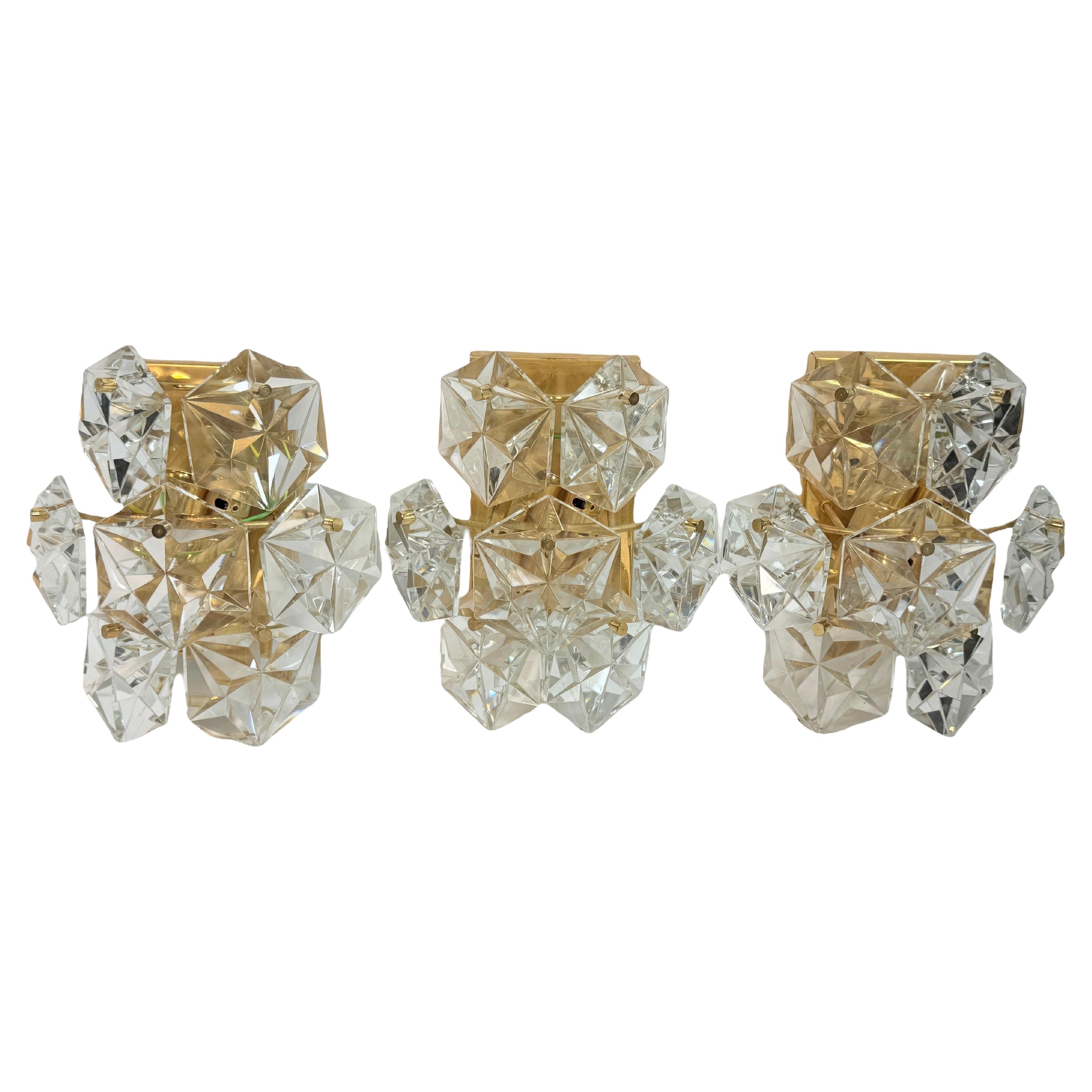 Set of Three Kinkeldey Gold-Plated and Crystal Glass Wall Lights, Germany, 1970s
An elegant set of three wall lights by Kinkeldey, crafted in Germany in the 1970s. Each fixture features a refined combination of gold-plated metal and faceted crystal