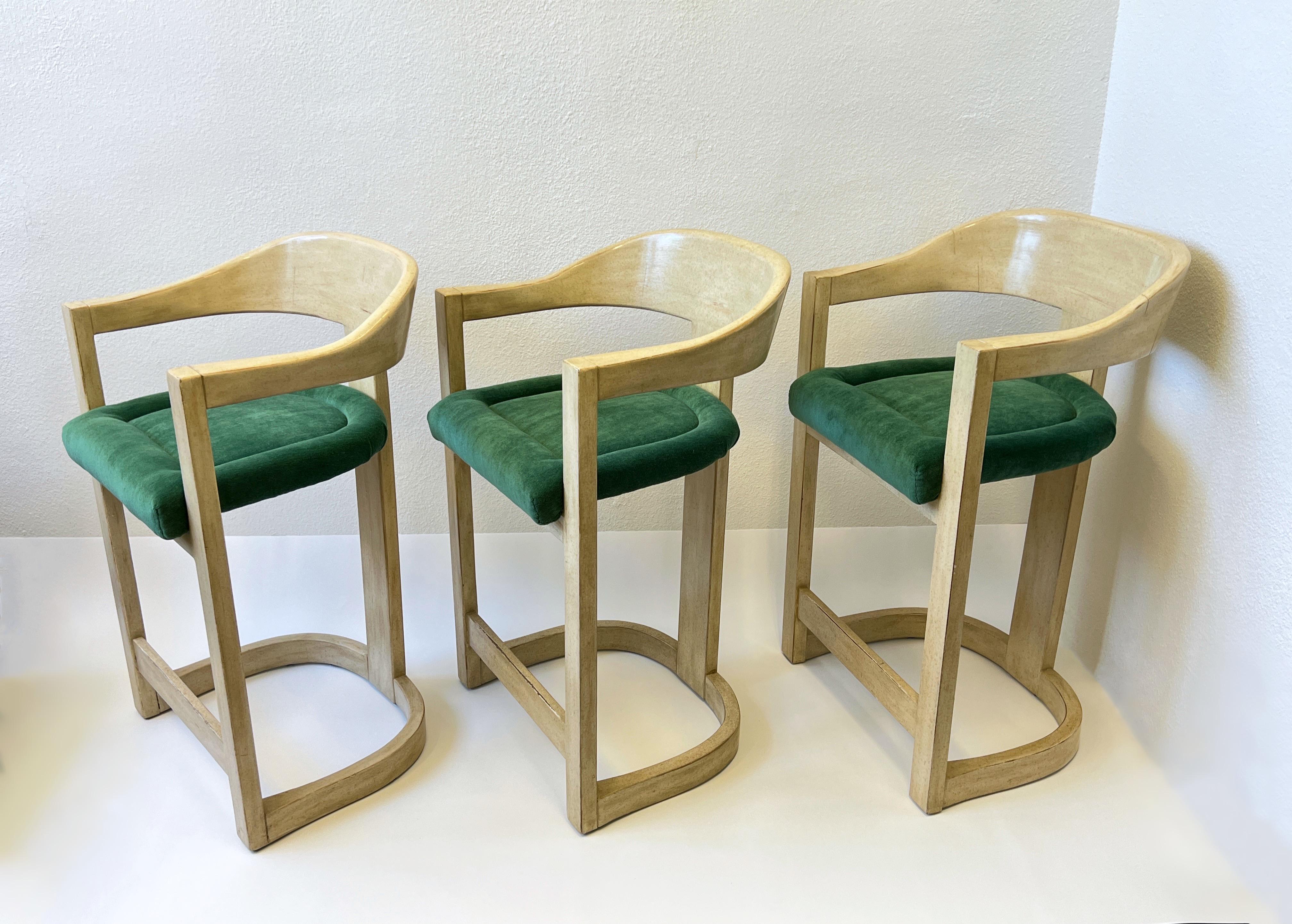 Set of three 1980’s off white lacquered ‘Onassis Barstools’ by Karl Springer for Steve Chase. 
Out of a Steve Chase Design Estate in Rancho Mirage CA. 
Constructed of carved wood with a off white speckled lacquered (see detail photos) and emerald