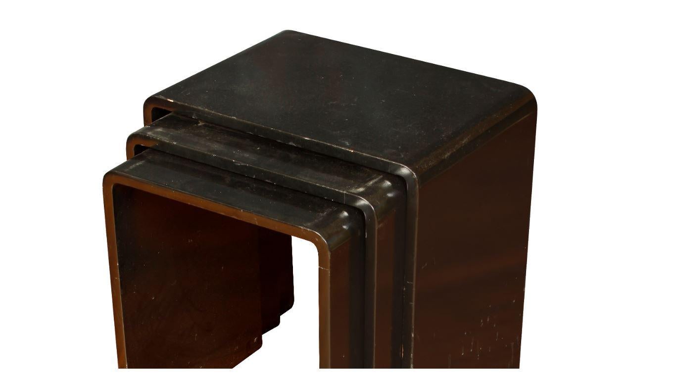 Set of three black lacquered nesting tables with curved waterfall edges.