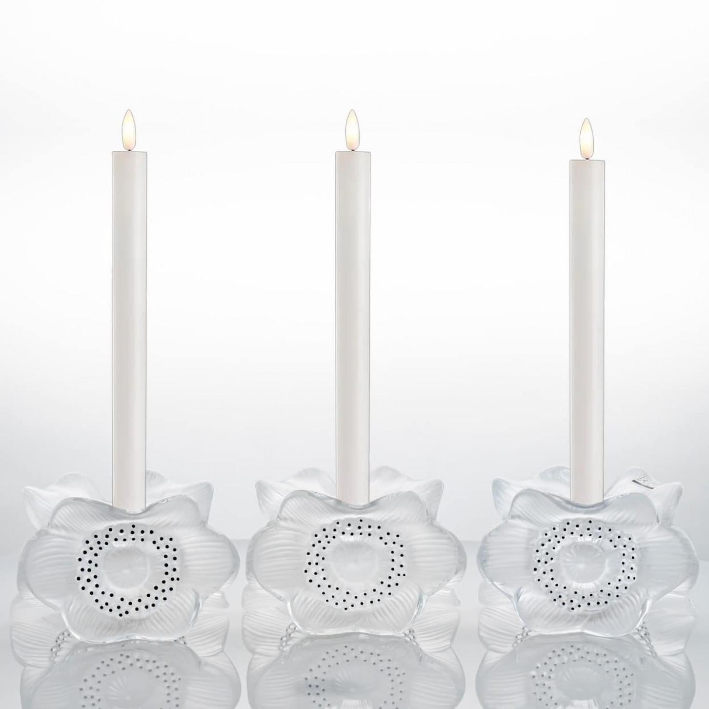 Luxury at its finest,  A collector’s item made by Lalique in France.

This is a pair of Lalique Three Anemones pattern (10922) Candle Holders in Perfect Mint Contition.

Designed by Marc Lalique in 1975. A combination of clear and frosted crystal