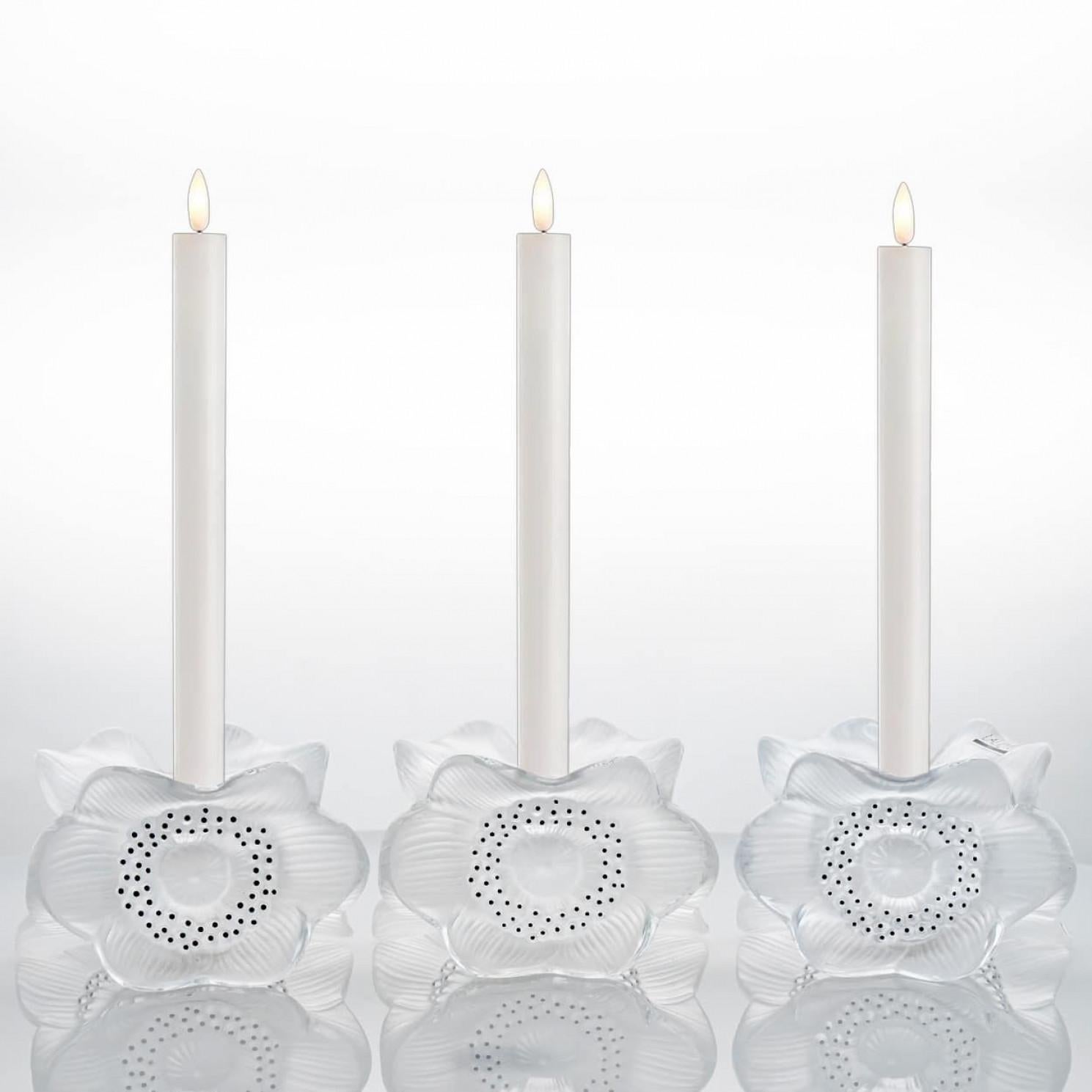 Luxury at its finest,  A collector’s item made by Lalique in France.

This is a pair of Lalique Three Anemones pattern (10922) Candle Holders in Perfect Mint Contition.

Designed by Marc Lalique in 1975. A combination of clear and frosted crystal
