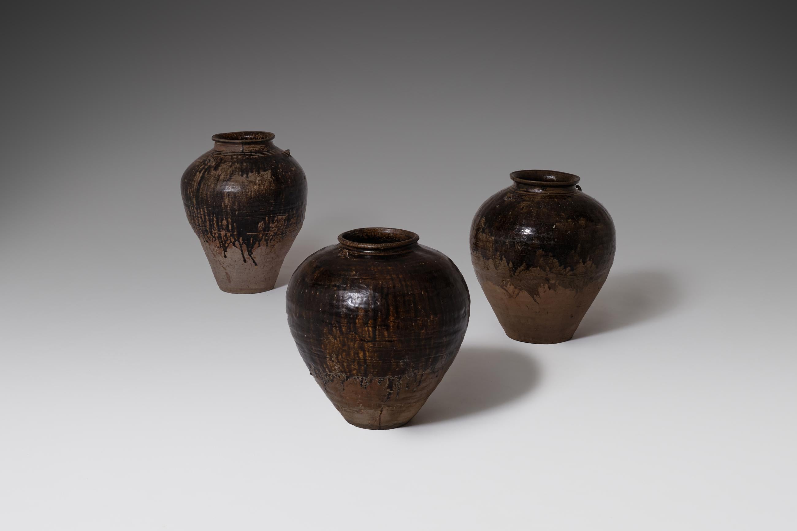 Set of three large ceramic pots from the Martaban area of Burma, 18th century. These large and heavy stoneware jars were used to store food, drinkwater etc; they were partly put in the ground with the unglazed surface, to keep the content of the