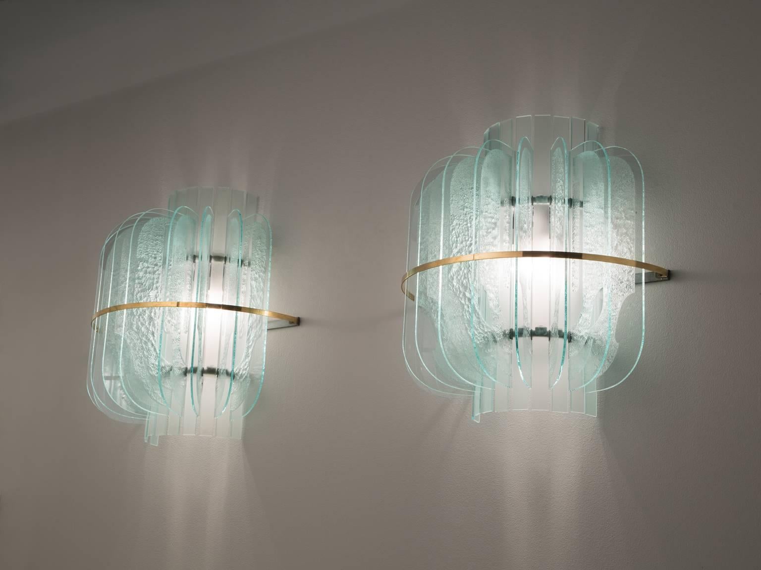 Set of three wall lights in glass, metal and brass, Italy, 1950s. 

Set of three large wall lights in structured glass and brass details. These lights are designed in the manner of Fontana Arte. A halve round design featuring nine structured and