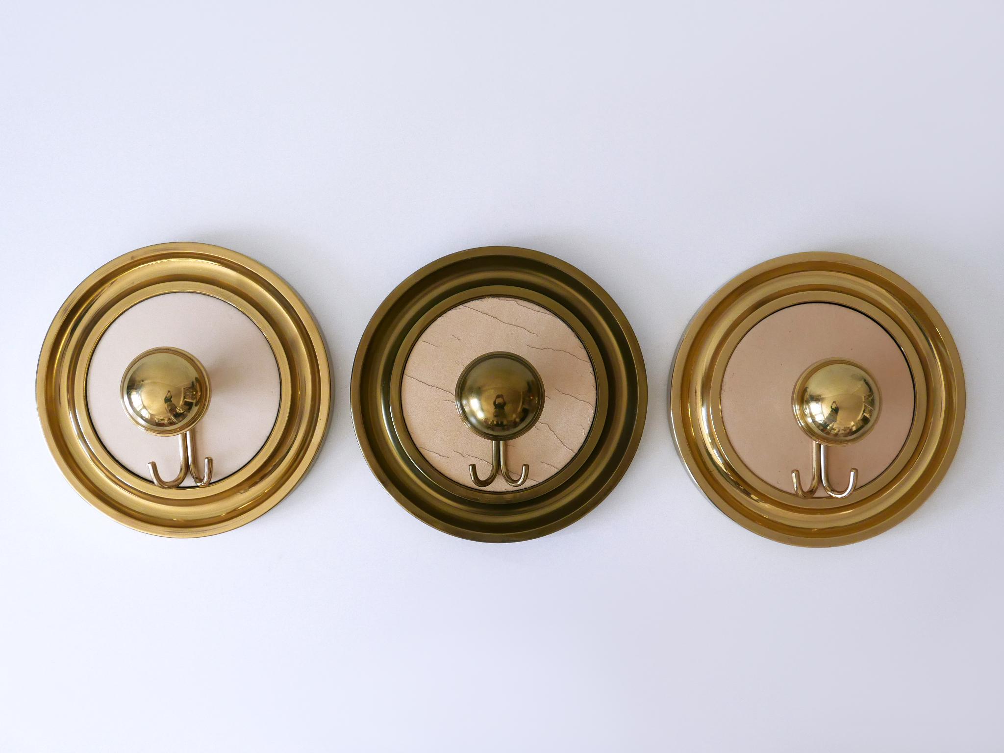 Ensemble de trois grands portemanteaux ou penderies murales, élégants et très décoratifs, de style Modern-Decor. Conçu et fabriqué probablement en Allemagne, dans les années 1960.

Exécuté en laiton massif.

Dimensions :
Dm 11.82 in. (30 cm)
D 14 cm