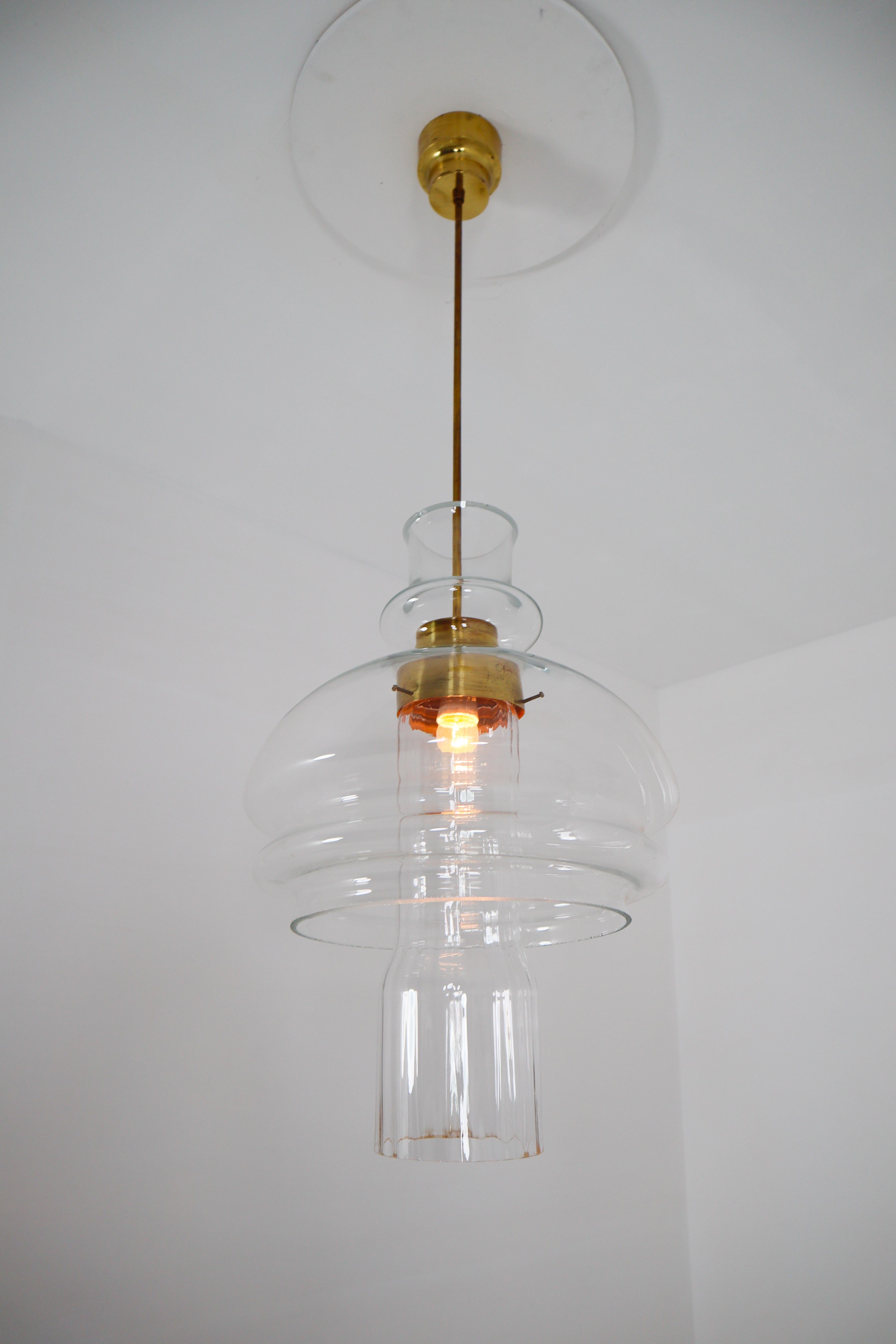 Large mid century  pendant, thick clear glass, Europe, 1960s. The diffuse light it spreads is very atmospheric. Completed with the clear hand blown glass and brass steel, these pendants will contribute to a luxurious character of the