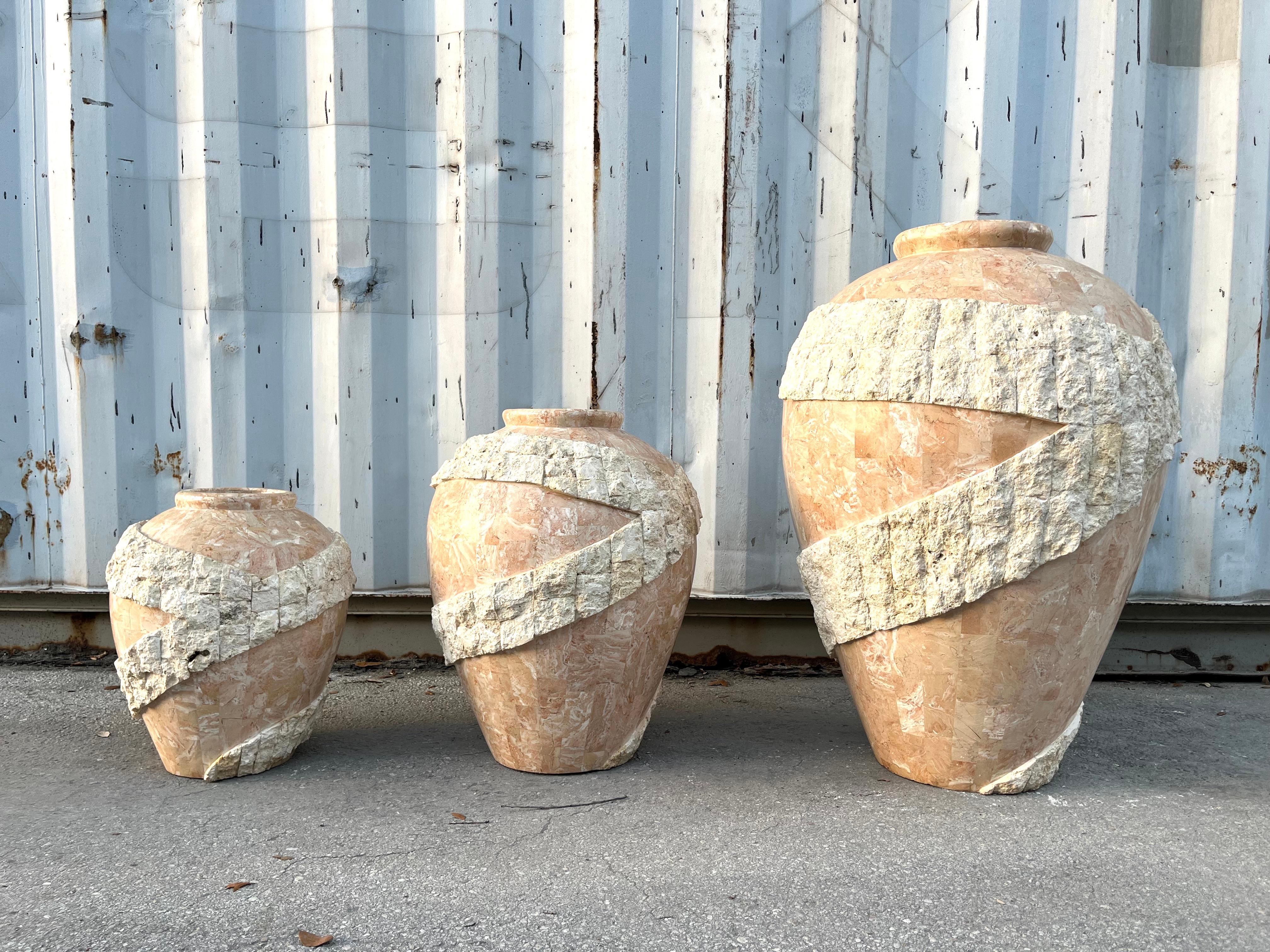 Ensemble de trois grands vases de sol postmodernes en pierre de Mactan, ornés de pompons. Vers 1980.
Feuteres Vases de sol en pierre de trois tailles, avec des corps polis, accentués par des détails en pierre brute de Mactan. 
En excellent état