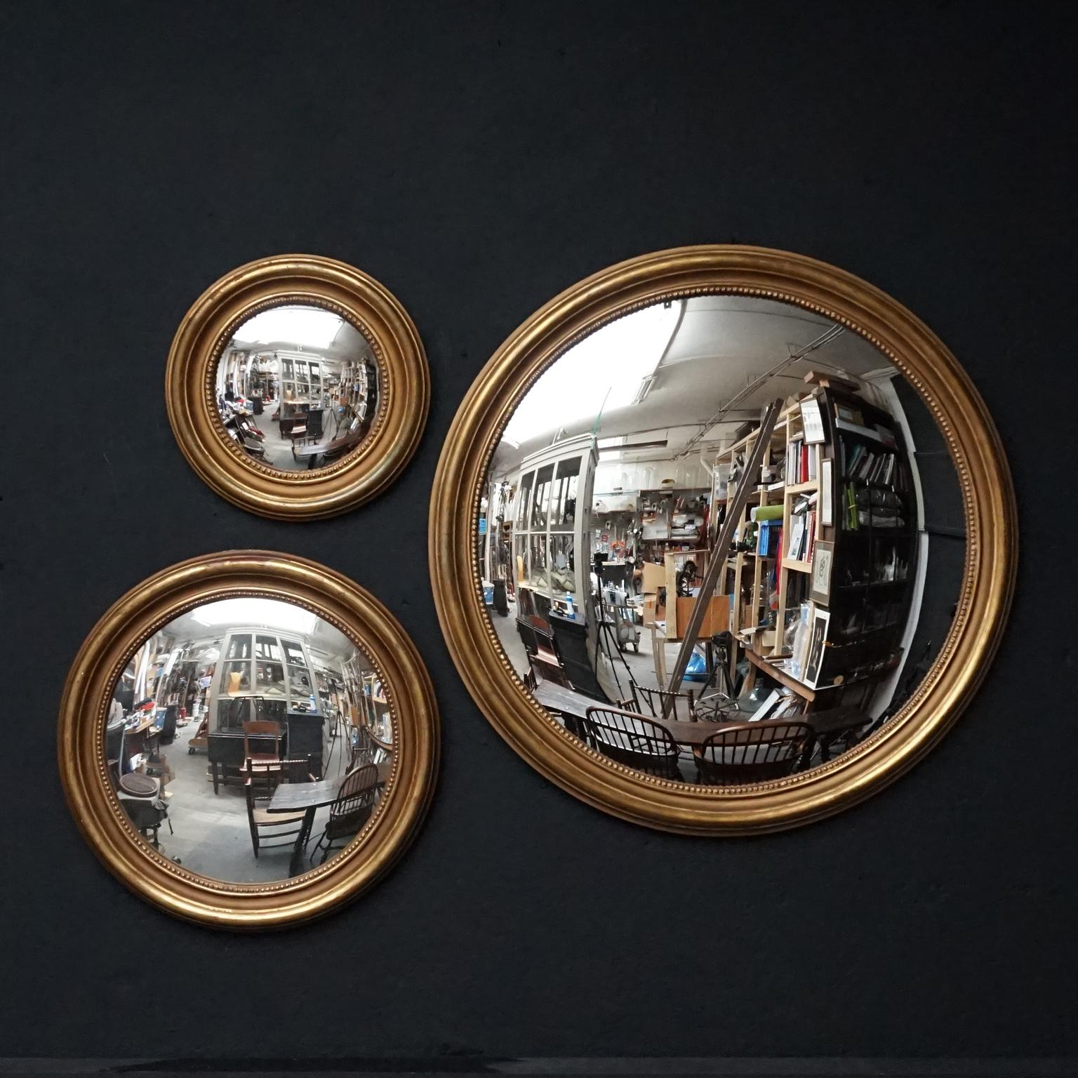 This perfect statement wall decoration consists of two (so not three, the 'medium' size is sold) round convex mirrors in relief pearled plastered giltwood frames. 
Great addition to any wall or an impactful statement on its own. 

Measures: Large