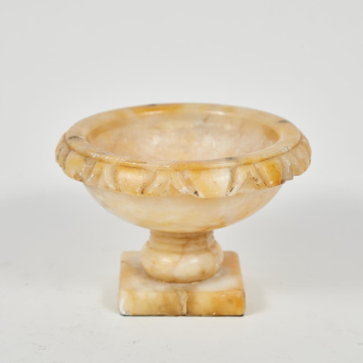 Set of three 18th-century Italian alabaster tazzas or jardinieres in graduating sizes. With a warm, sunny hue, rounded egg and dart rim, and square pedestal bases, the set makes a classical, romantic addition to indoor and outdoor spaces