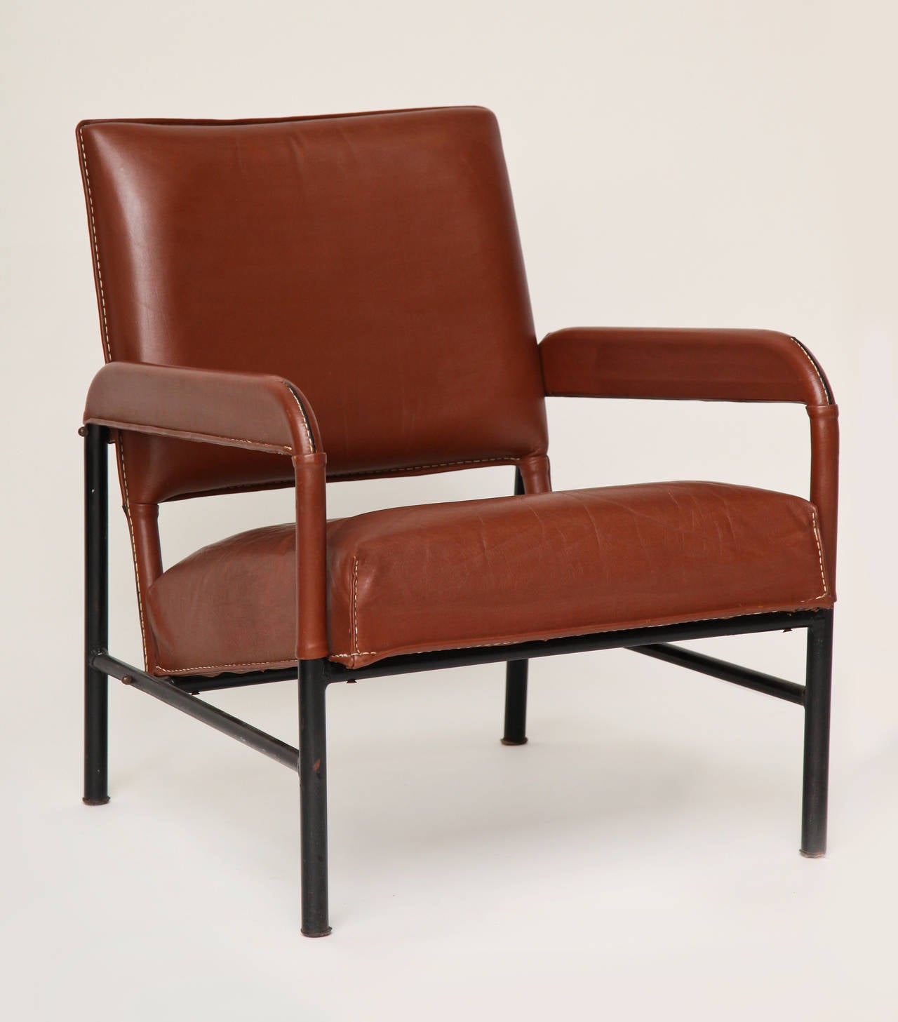 Set of three leather and cast iron armchairs in the manner of Jacques Adnet.