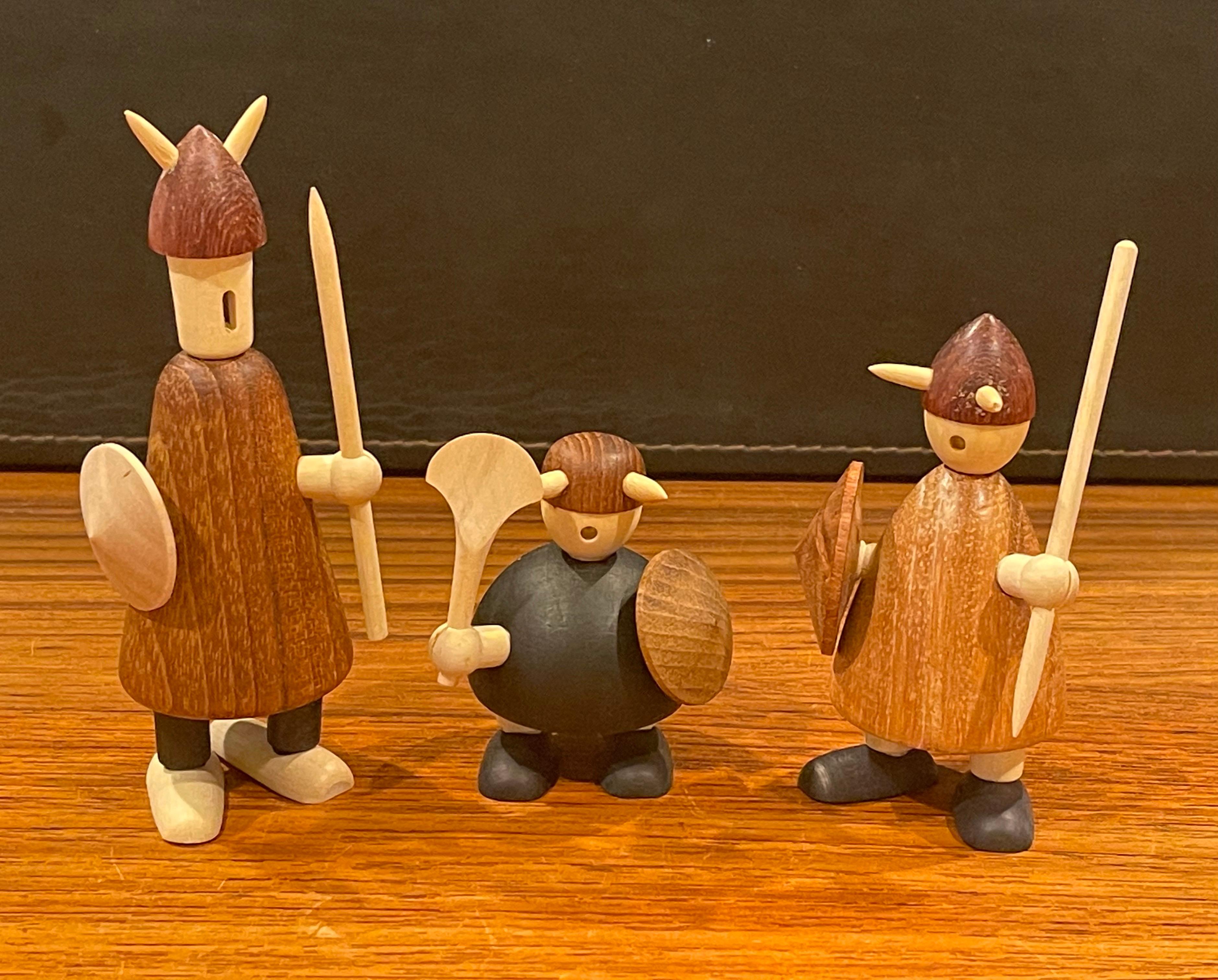 Set of three like new midcentury Danish viking figures made of mixed woods with original box and pamphlet by Jacob Jensen, circa 1950s. The figures are in excellent vintage condition and measure: 5.5