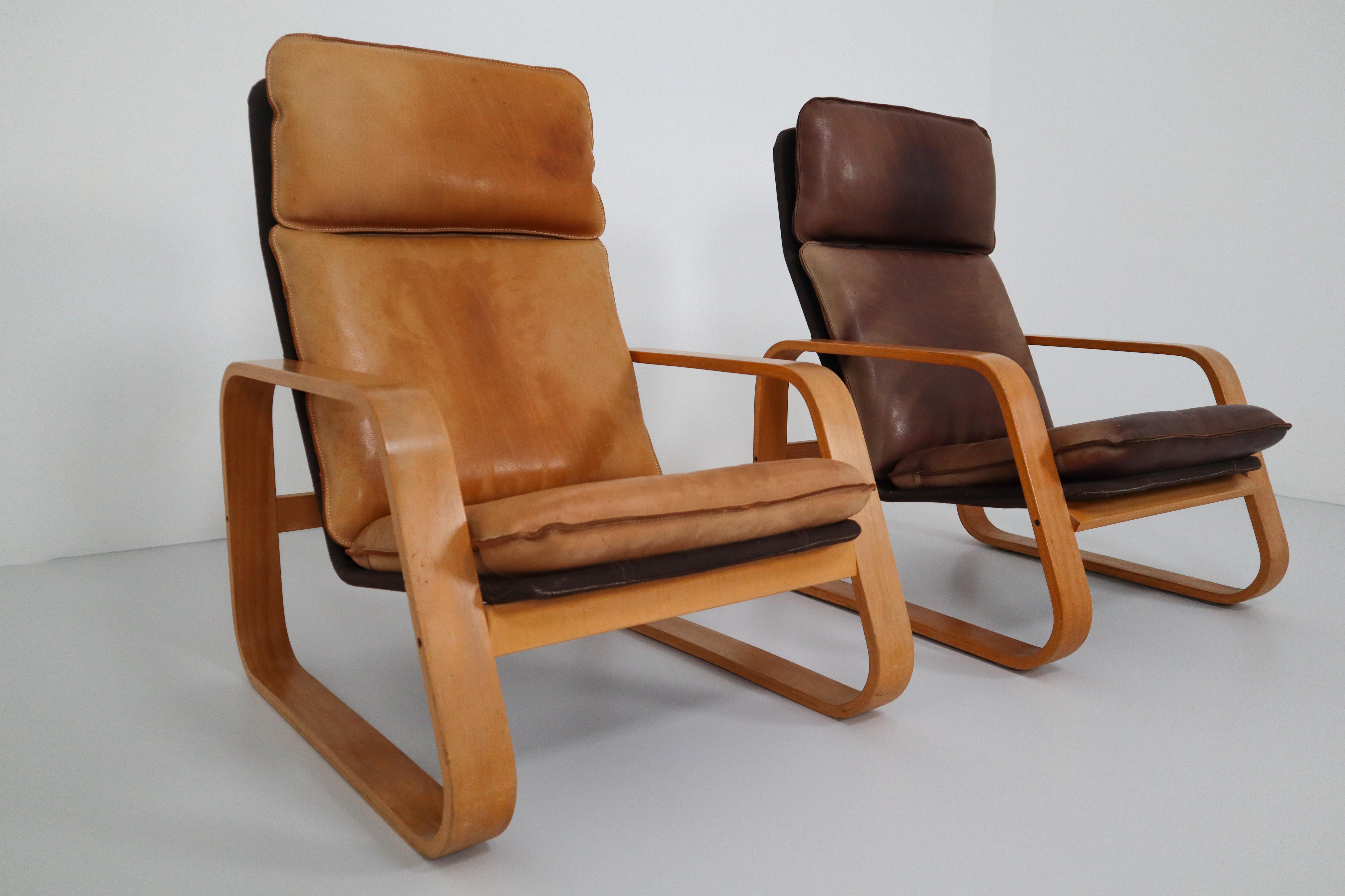 Set of three late midcentury lounge chairs, patinated leather, bentwood and fabric, France, 1970s.

These comfortable armchairs in bentwood and patinated saddle leather of this set, features a wonderful and rich patina and is therefore especially