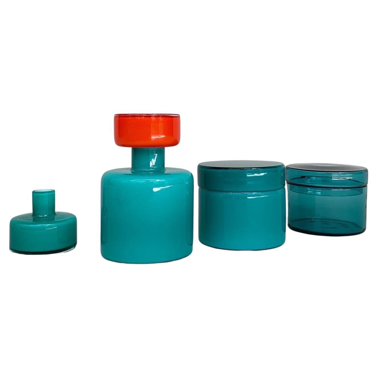 Rare Murano glass bottle decanter & matching jars, designed by Luciano Vistosi and hand-crafted by Vistosi glass factory in Murano in the 1960s. 

White layered glass with a vibrant turquoise and clear teal color.

Measures: Bottle
Height: 17