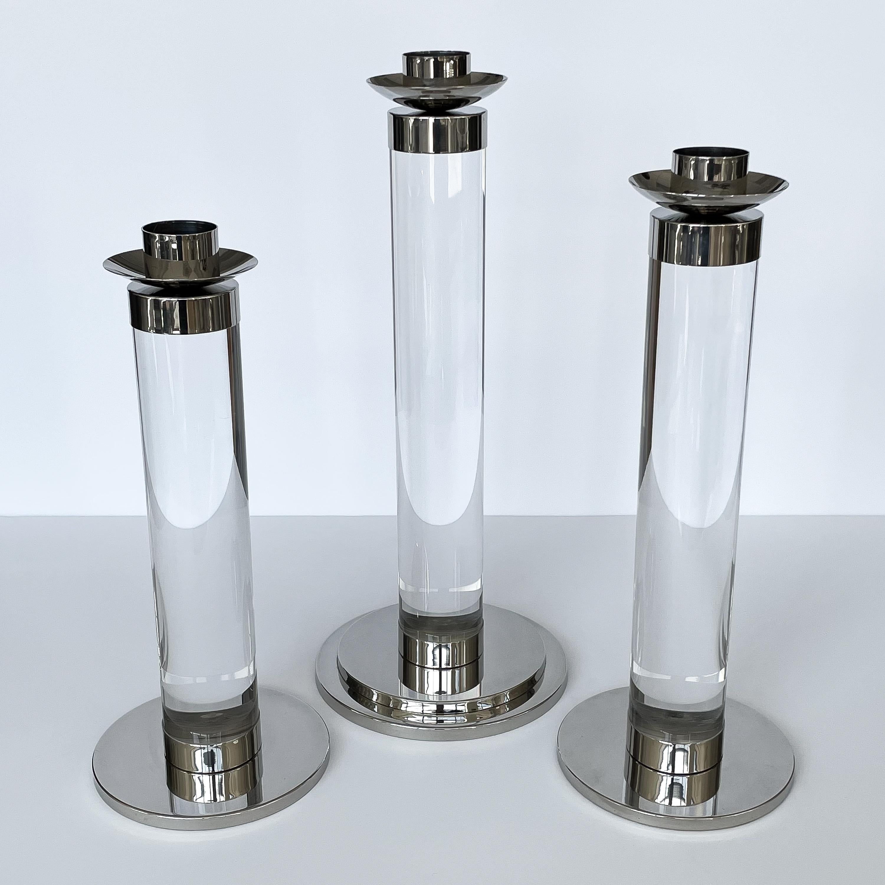 Set of three Italian large lucite and chrome candlesticks, circa 1970s. Three candlesticks in graduating heights: 18.5