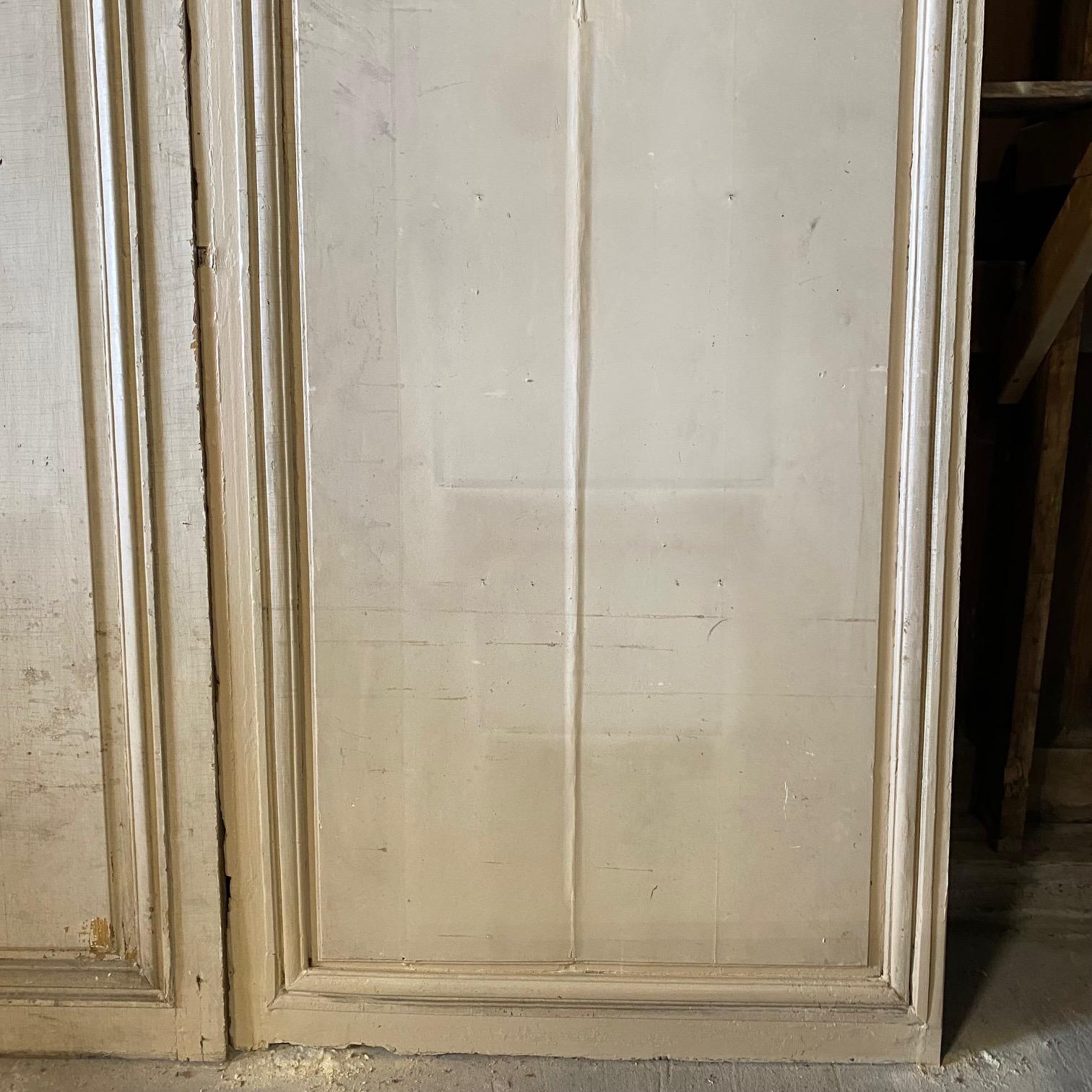 Stunning set of three almost 10 feet tall, monumental early French panels that were removed from an important chateau in France. These large panels are in the Louis XV style and showcase a Fleur de Lis crest in the center of each. All are painted in