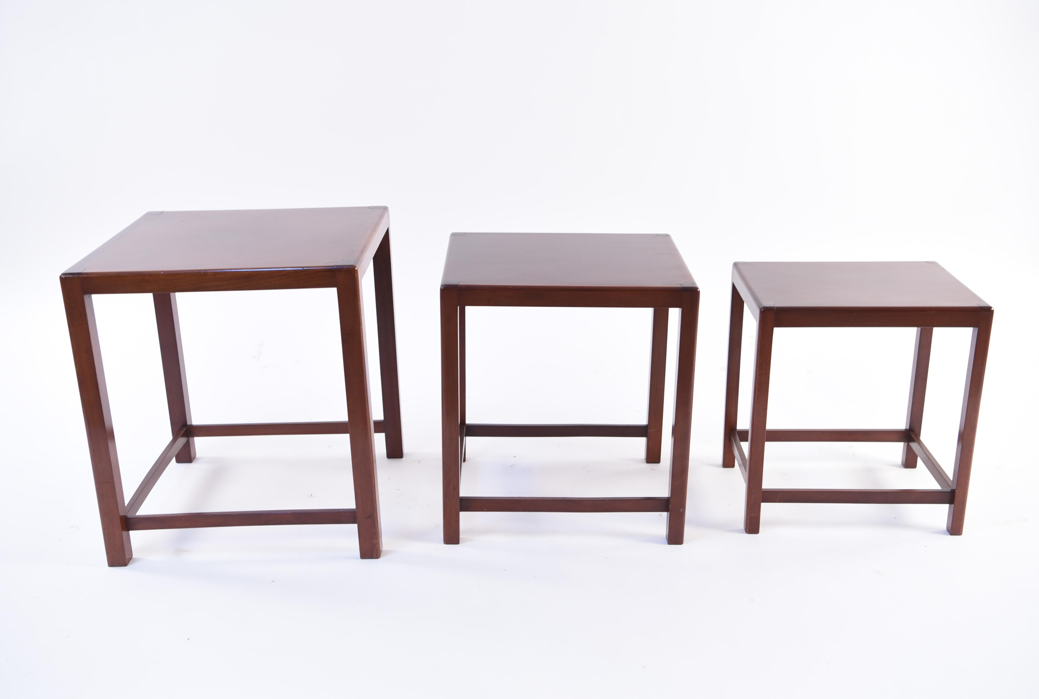 A set of three nesting tables in mahogany wood by Fritz Hansen, circa 1950s. This set has clean, Minimalist lines which gives it a pleasing, modern appearance. The tables nest well with a small footprint, yet can be used independently in an interior