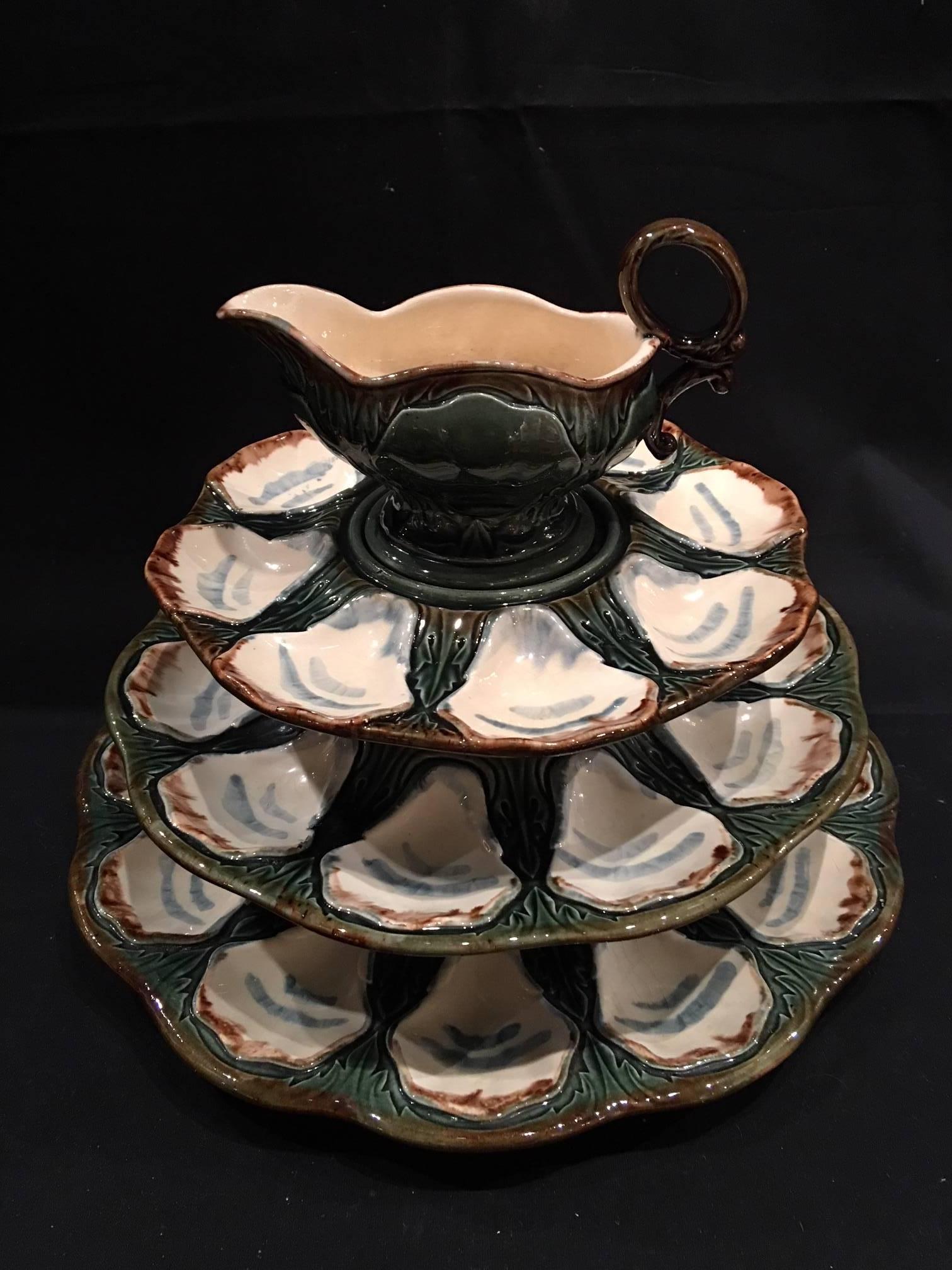 Set of three Majolica long champ Terre oyster platters and a sauce boat, 19th century. Large platter is 14