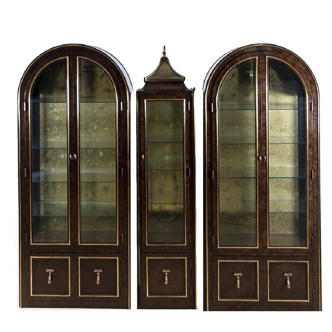 A set of three William Doezema for Mastercraft display cabinets, 20th century. Each featuring an eye-catching burled Amboyna wood
Three freestanding parts: two large round-top burl wood side cabinets. The middle tall narrow cabinet having a brass