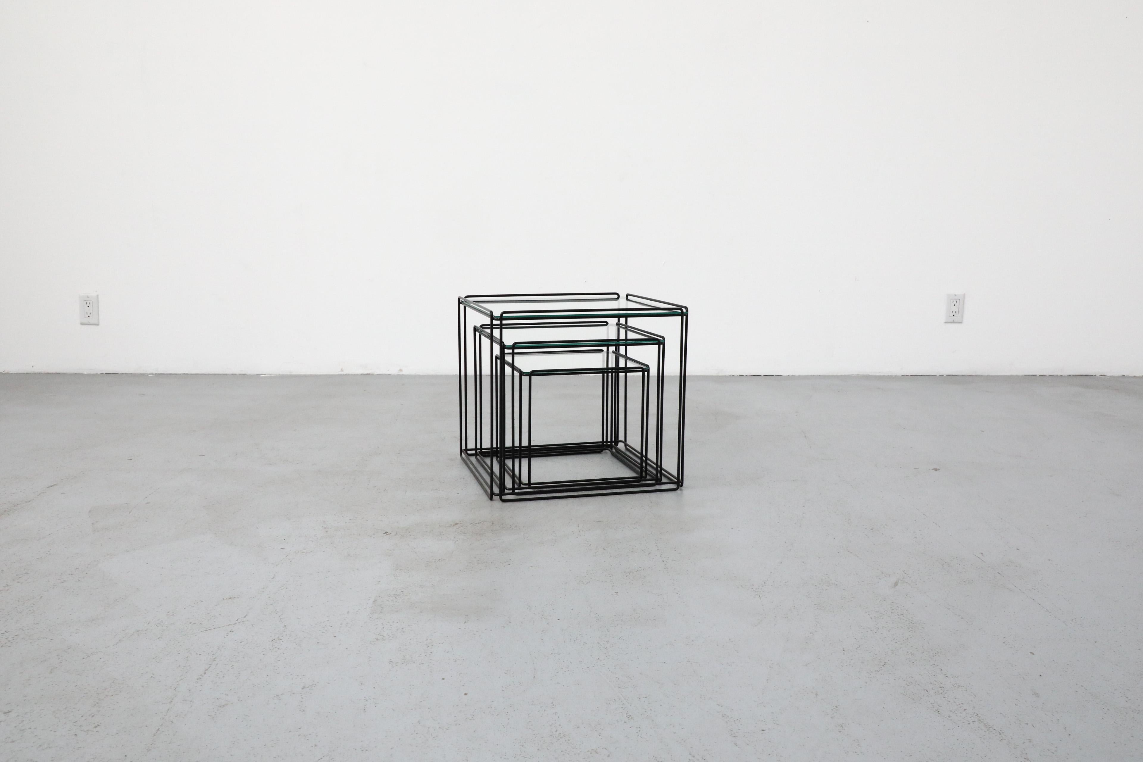 Mid-Century minimalist wire framed cube nesting tables, designed by Max Sauze in France for Atrow, 1970s. The tables feature thin black enameled frames and inset glass tops. They are in original condition with wear that's consistent with their age