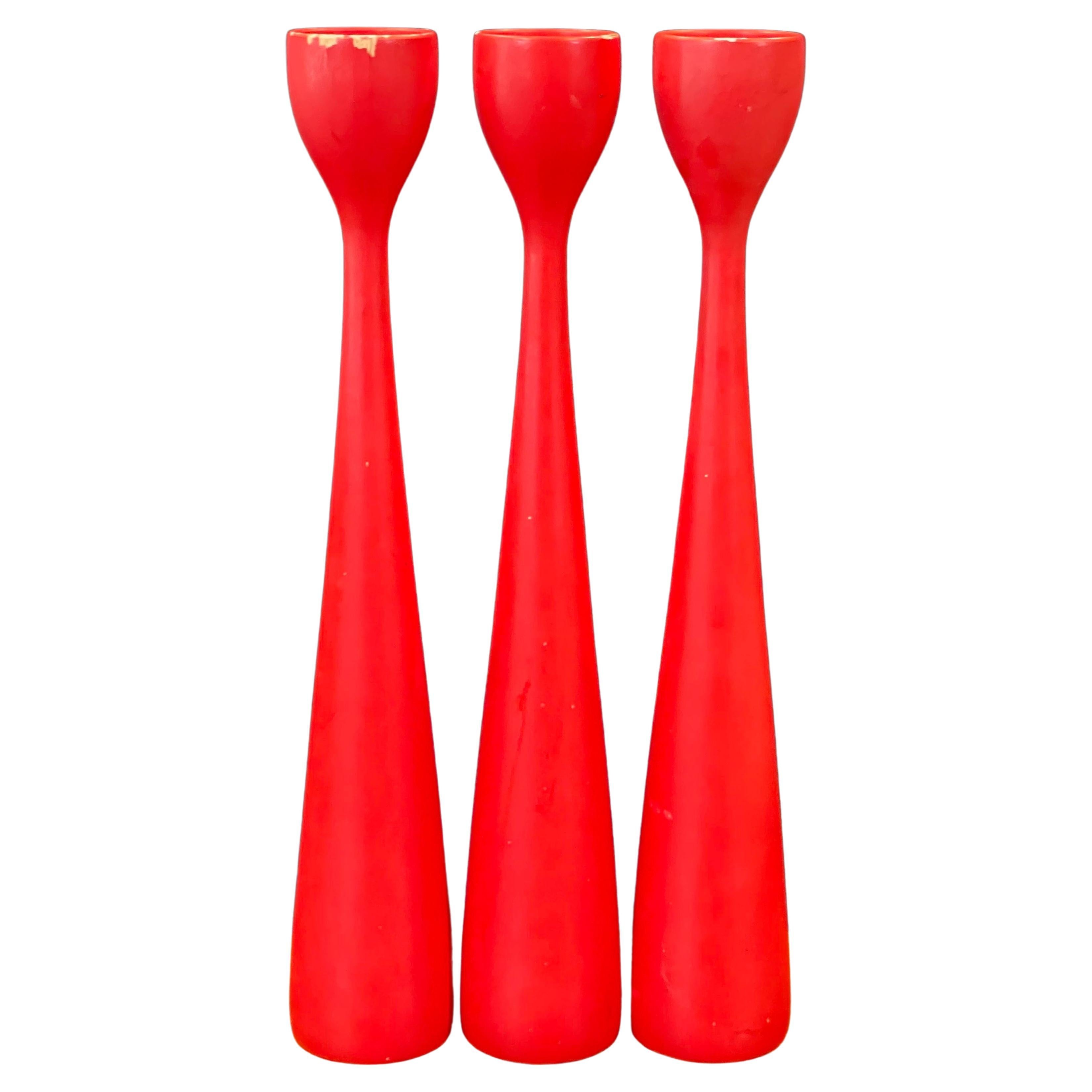 A nice set of three MCM red hardwood candlesticks by Illums Boulghus of Denmark, circa 1960s. The set has a great well worn look (some chips just add to the character) and each stick measures 2