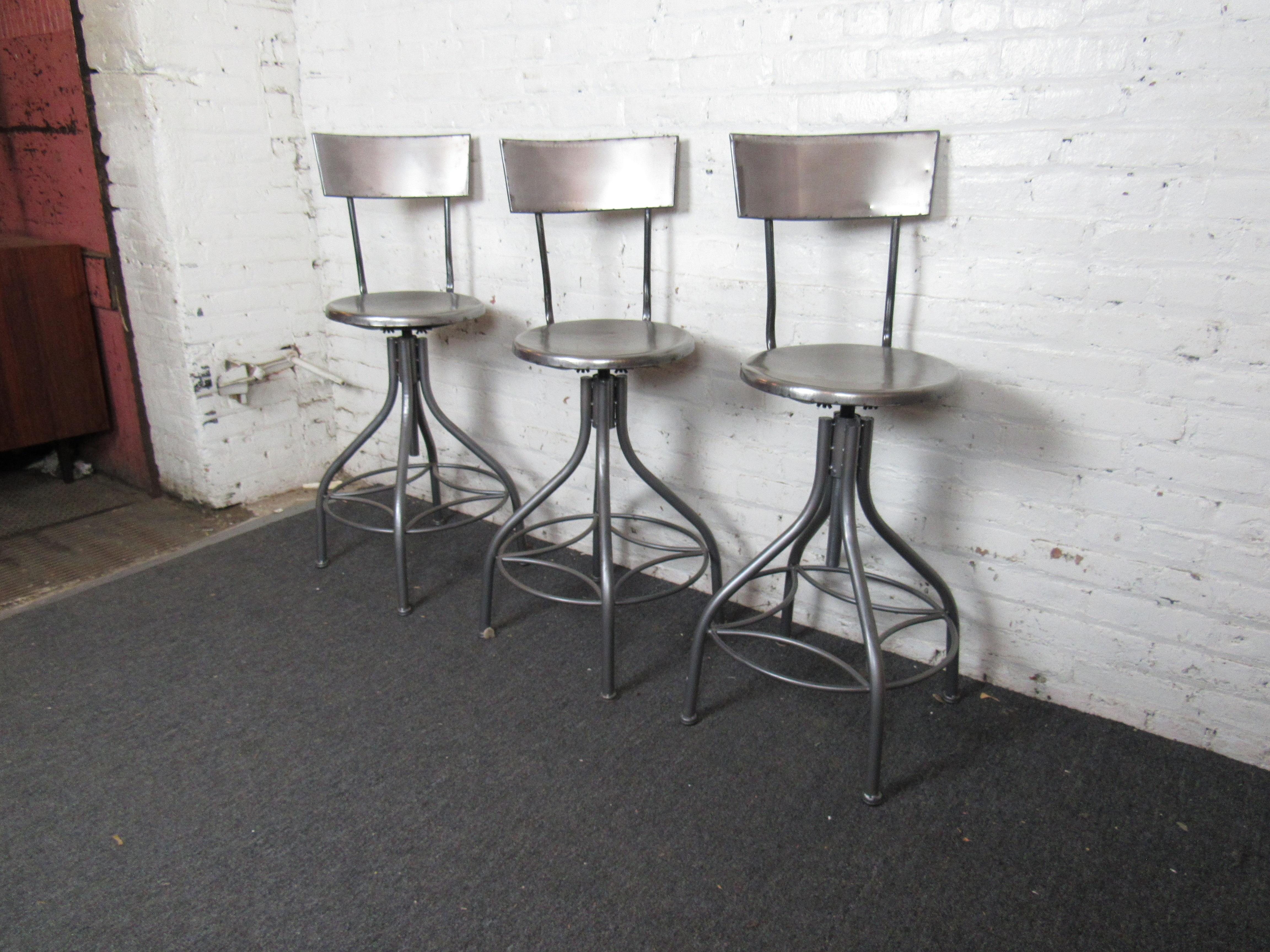 Set of three elegant metal barstools with swiveling tops, perfect for adding an element of vintage flair to any space. Please confirm item location with seller (NY/NJ).