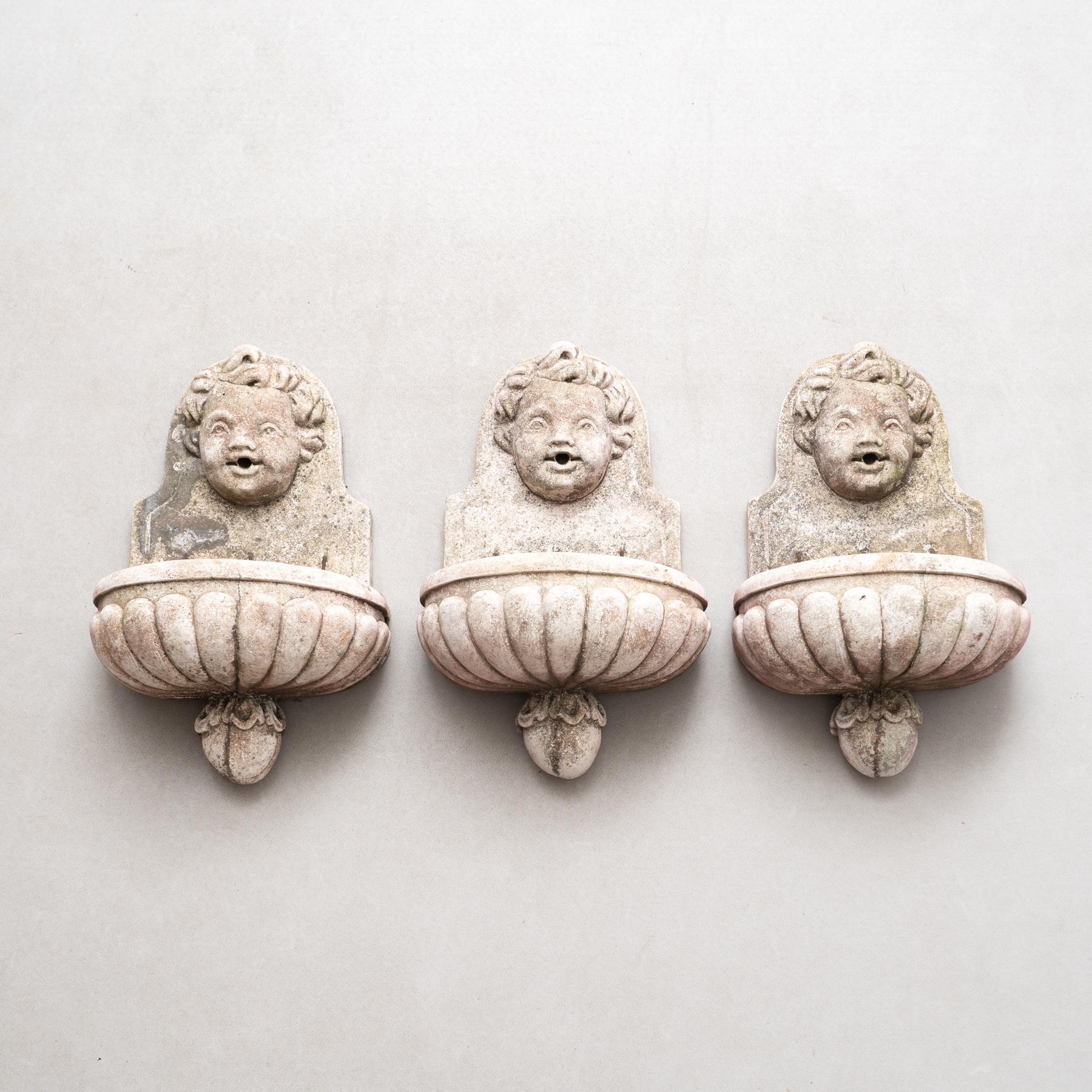 Enhance your outdoor space with this exquisite set of three mid-20th century wall fountains, crafted circa 1950 by an unknown manufacturer in France. Made of durable concrete, these fountains showcase an incredible patina that adds timeless charm