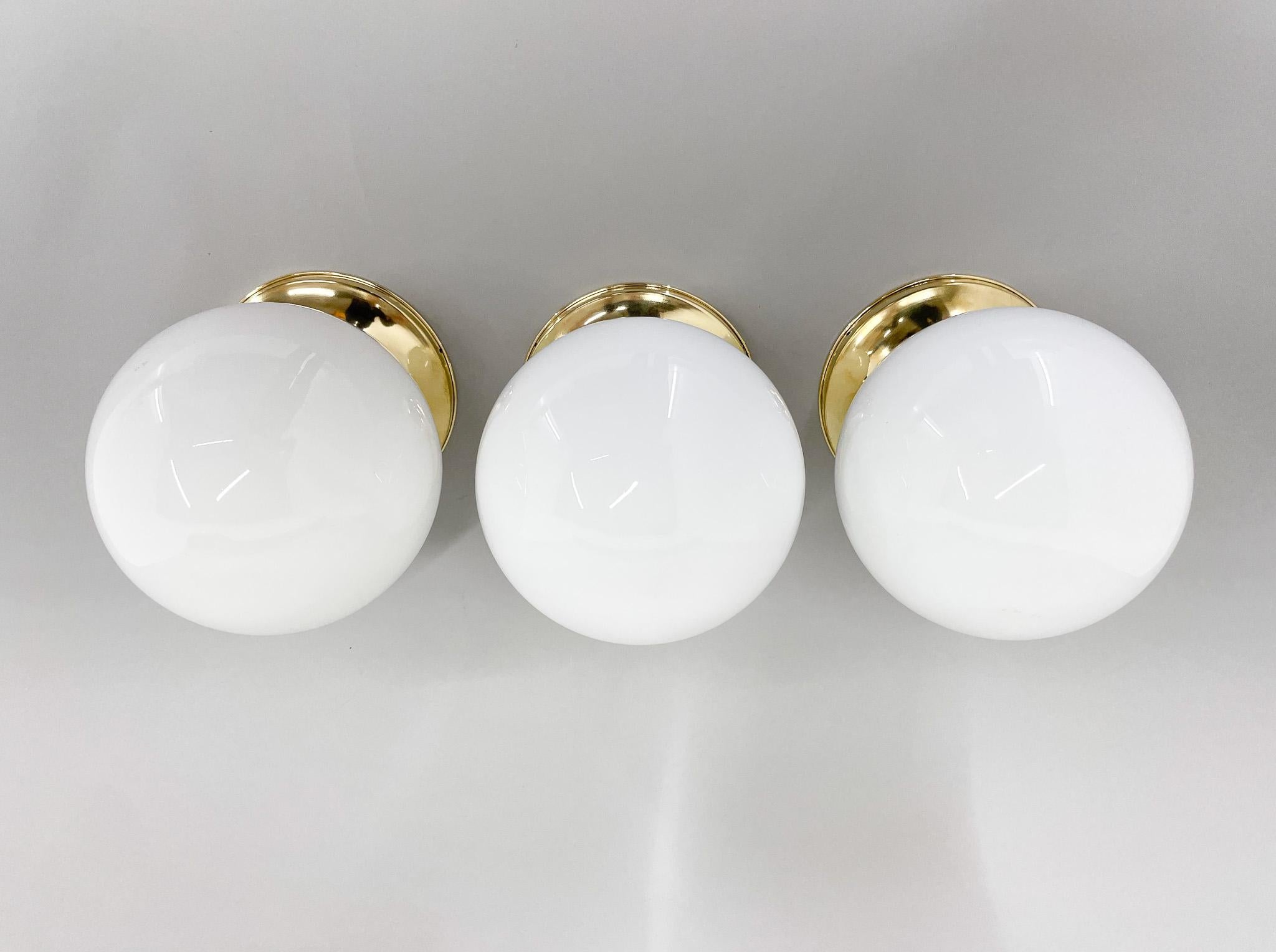 Mid-Century Modern Ensemble de trois plafonniers en laiton et verre au lait du milieu du siècle dernier, restaurés en vente