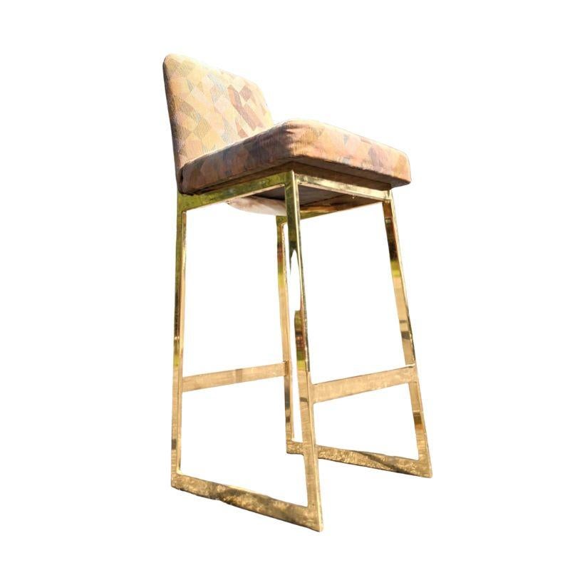 Ensemble de trois tabourets de bar dorés de style moderne du milieu du siècle, avec sièges et dossiers rembourrés.  L'ensemble de tabourets de bar a une base géométrique angulaire en métal doré avec deux brancards droits à l'avant et à l'arrière. 
