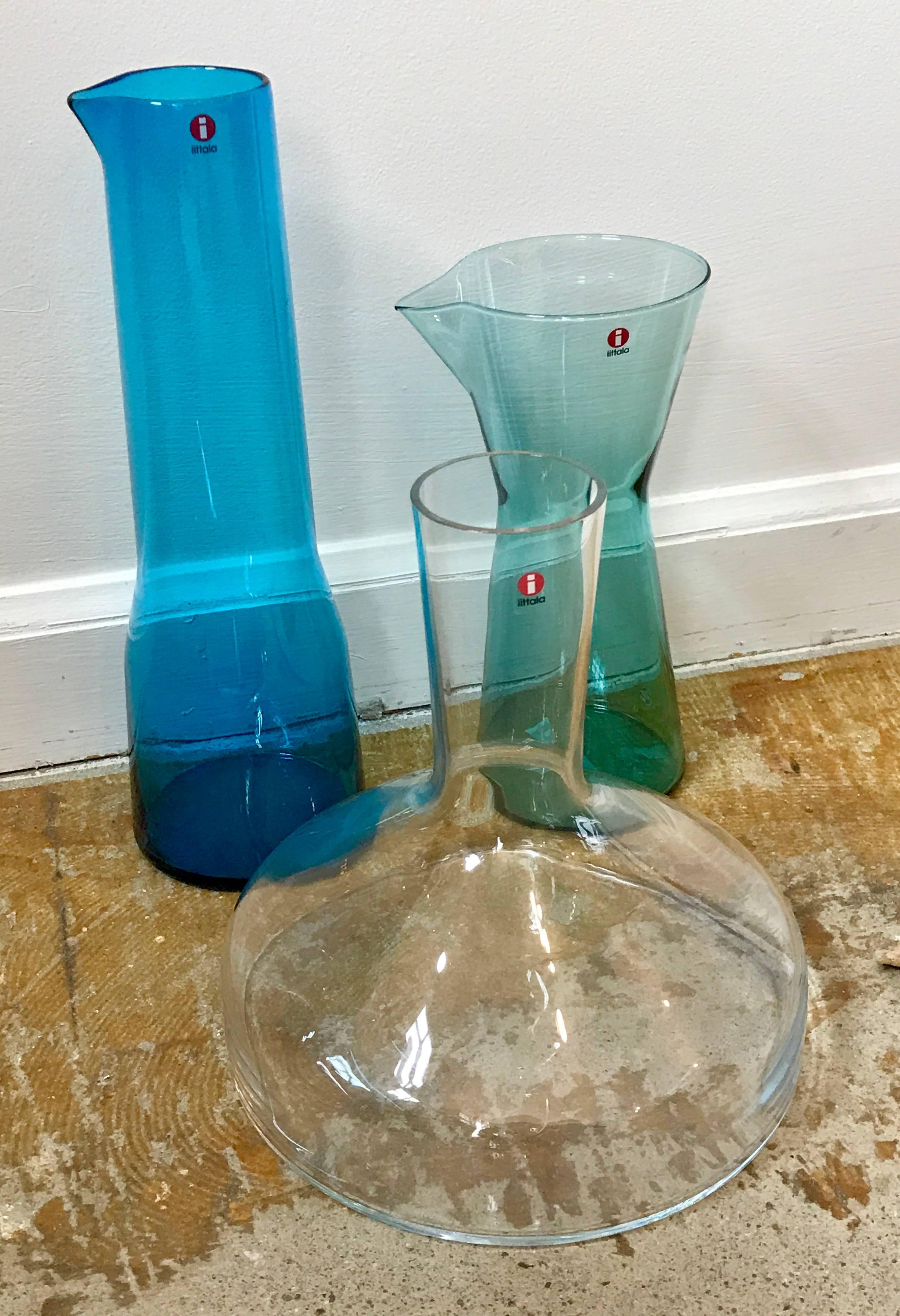 Set of three Iittala Finland decanters in like new unused condition. Consisting of one wine decanter and two beverage vessels. Iconic design by Kaj Franck.