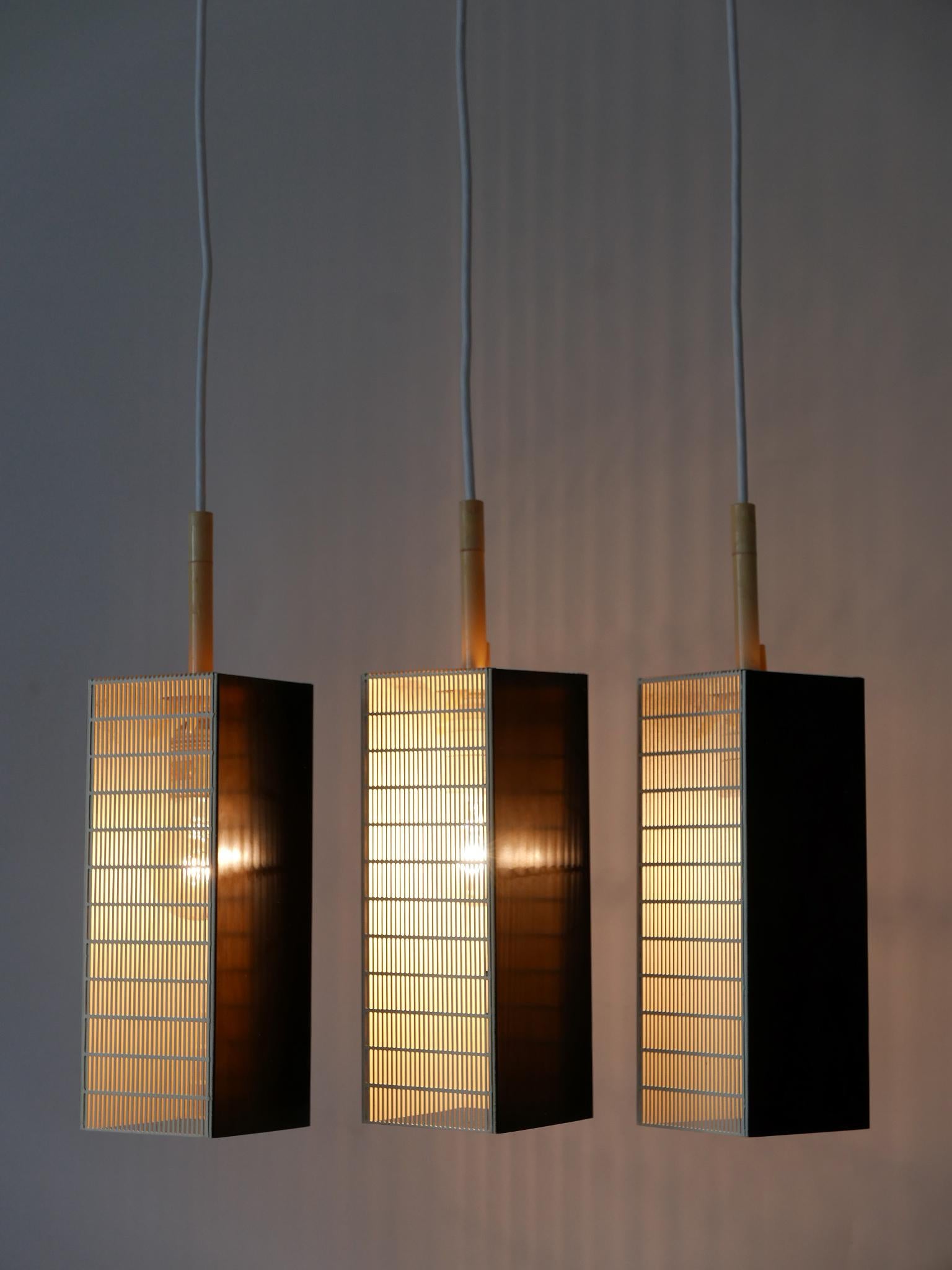 Set of three rare, lovely and elegant Mid-Century Modern pendant lamps or hanging lights. Manufactured by Staff Leuchten, Germany, 1960s.

Executed in white and black enameled and perforated metal, each pendant lamp is executed with 1 x E27 / E26