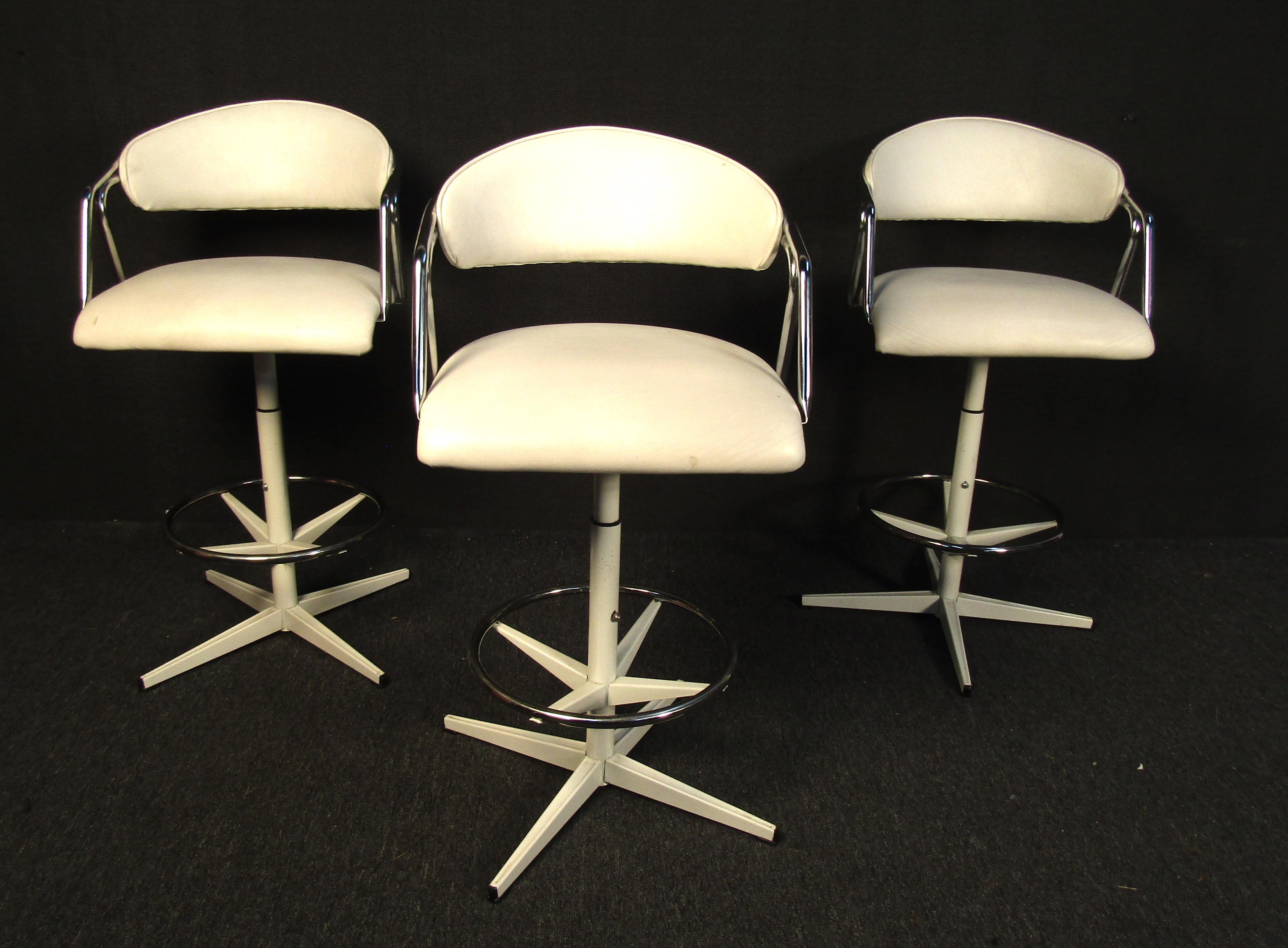 Set of three vintage modern barstools. Upholstered in white vinyl, these unique retro swivel barstools with chrome accents would make a beautiful addition to any bar. 

Please confirm item location (NY or NJ).