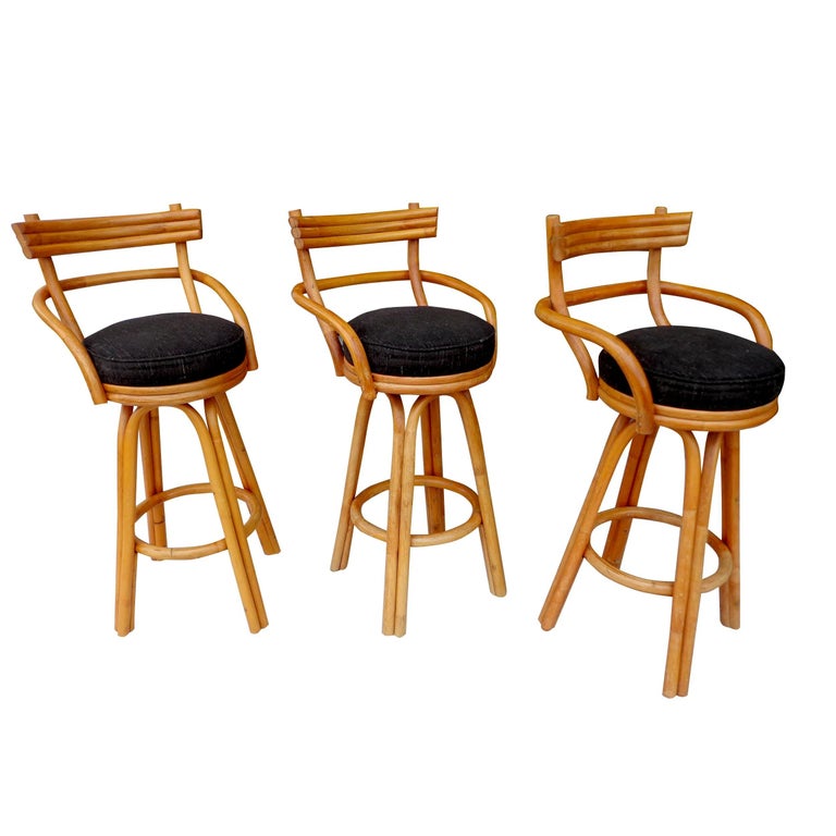 Set of three Paul Frankl bamboo rattan stools 

A set of 3 stools in carved bamboo and rattan by Paul Frankl.
Upholstered in black fabric. Swivel mechanism.
Good vintage condition.
 