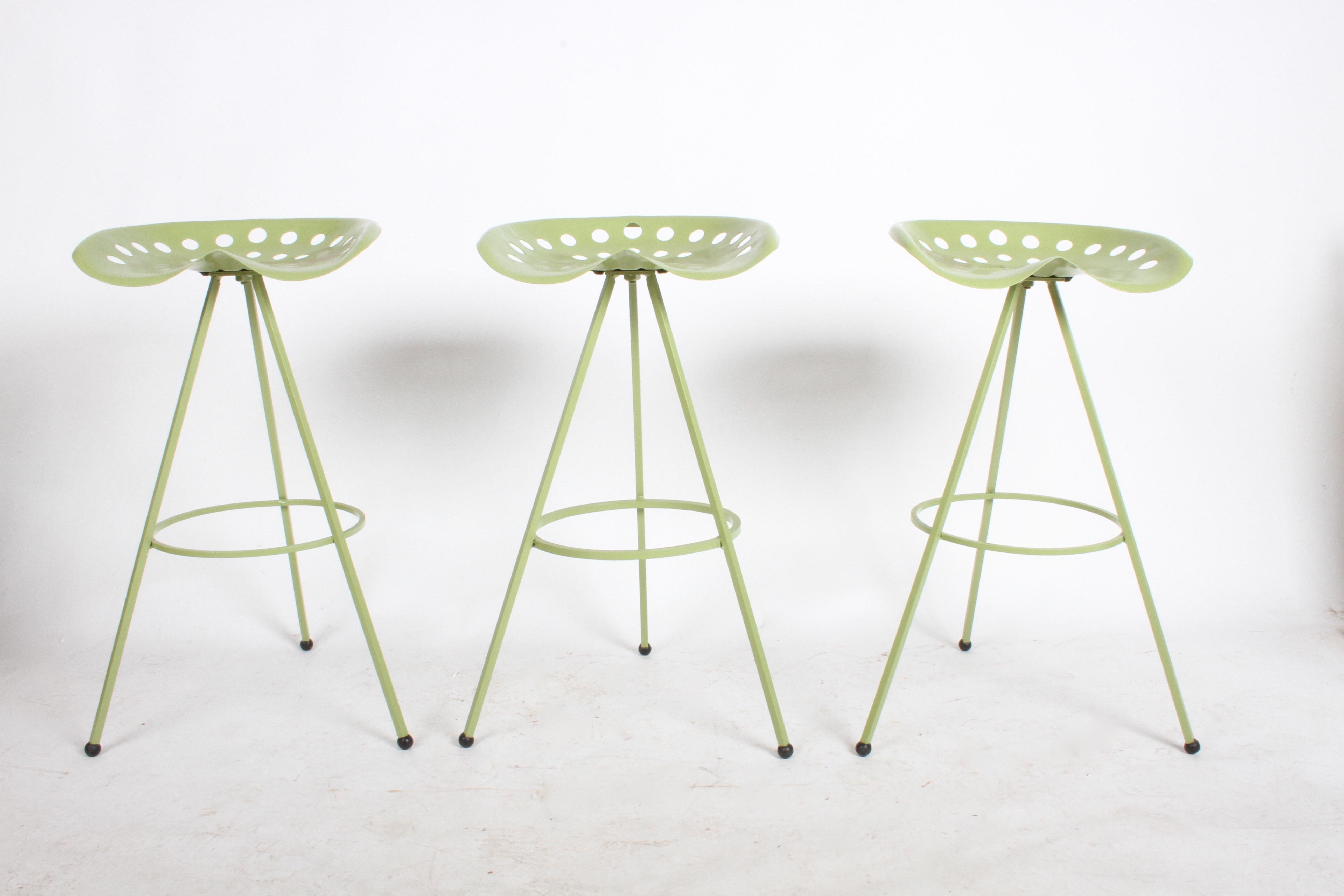 Fully restored set of three vintage Mid-Century Modern tractor seat bar stools on a tripod base with original glides. They have been sandblasted, primed and painted green. The green was a match of the original color of the tractor seat. Can be