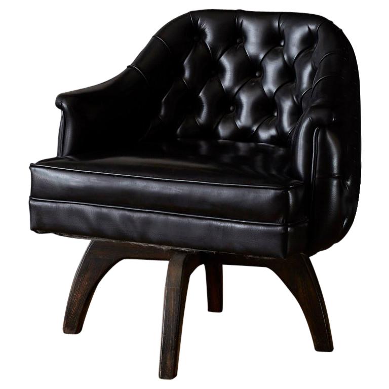 Wicked set of three Mid-Century Modern tufted black leatherette or Naugahyde club chairs. Featuring a rare tufted front and backside with a wooden four leg swivel base. Shiny and thick black Naugahyde with beautiful grain patterns tufted in the