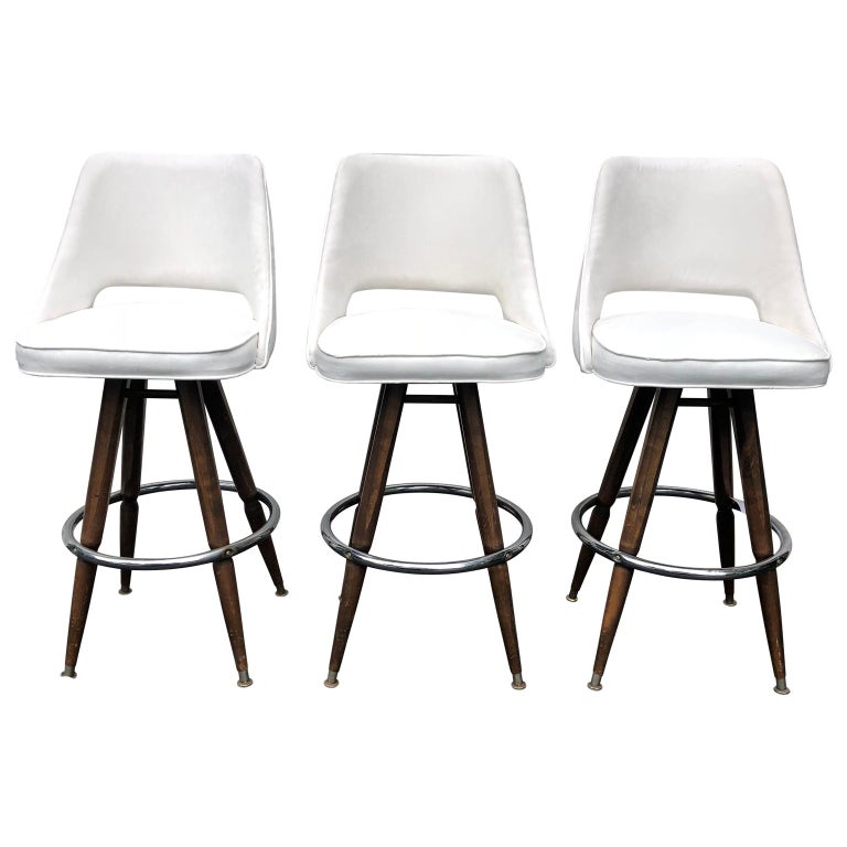 Set of three mid-century white faux-suede bar stools

3 large sturdy bar stool on wooden and chrome legs and with upholstery in white spill-proof faux suede.