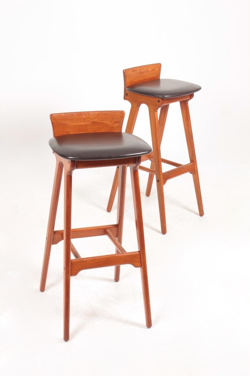 Set of three great looking bar stools in solid teak and patinated leather. Designed by Erik Buch.