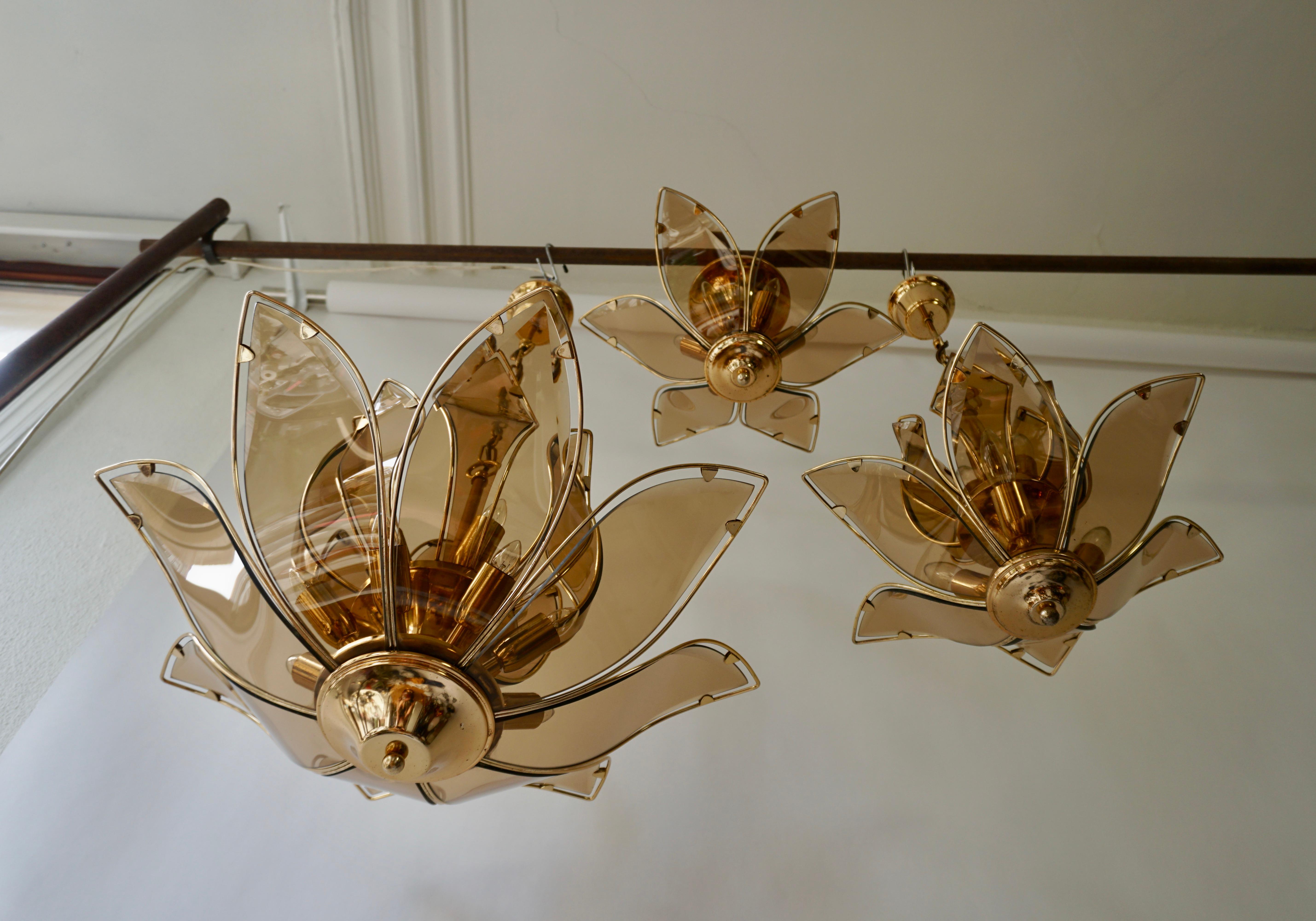 Two chandeliers and one flush mount in brass and glass. Italy 1970s.
Dimensions;
Chandelier: Diameter 64 cm, height fixture 50 cm, total height 85 cm. Twelve E14 bulbs.
Chandelier: Diameter 48 cm, height fixture 44 cm, total height 73 cm. Six E14