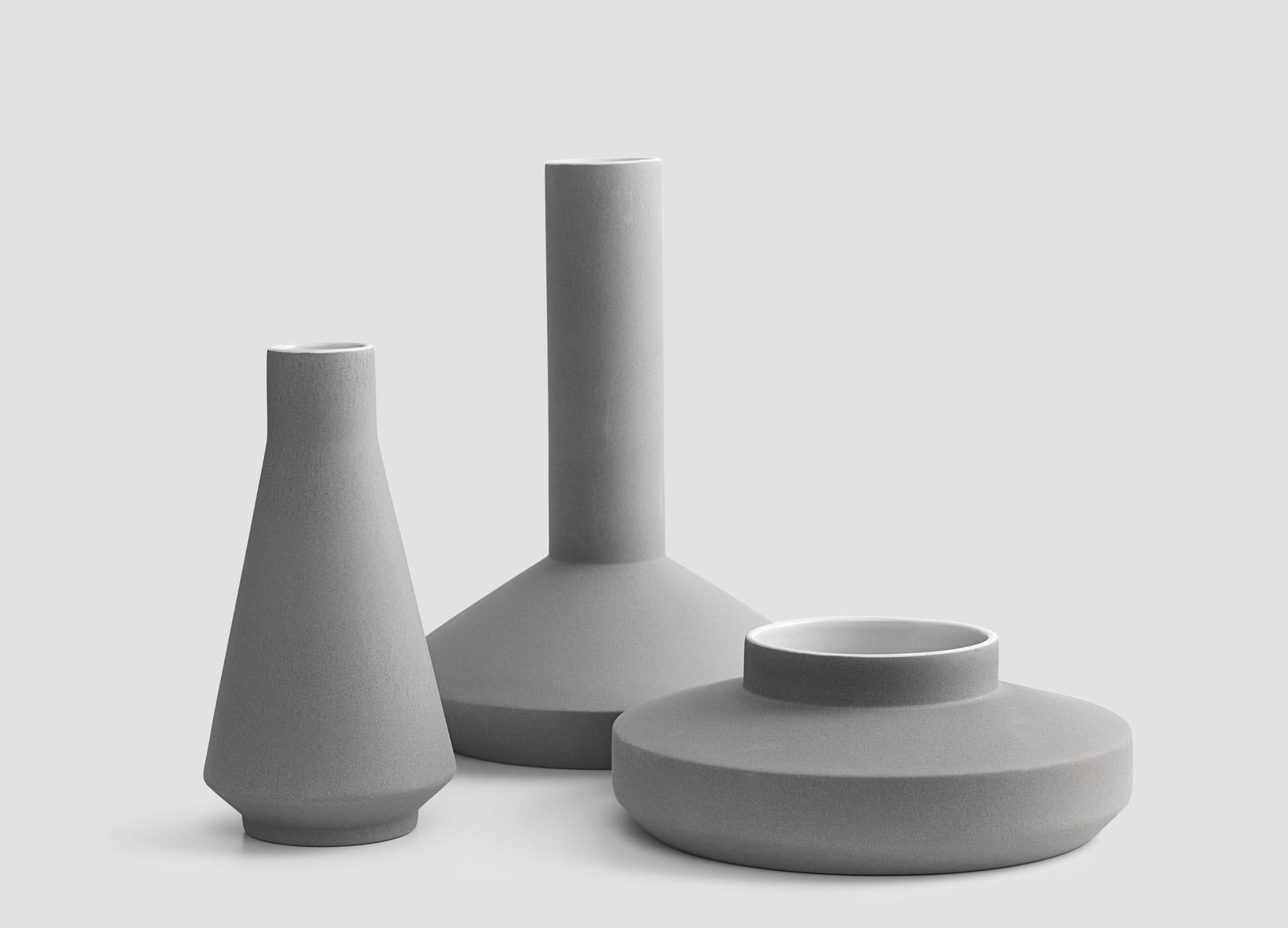 Vases designed by Milia Seyppel in 2011.

Industrial beauty. Inspired by industrial architecture, machinery, and tools for mass fabrication. Straight lines, sharp edges, clear shapes. Wrapped in a velvety soft surface reminiscent to concrete or