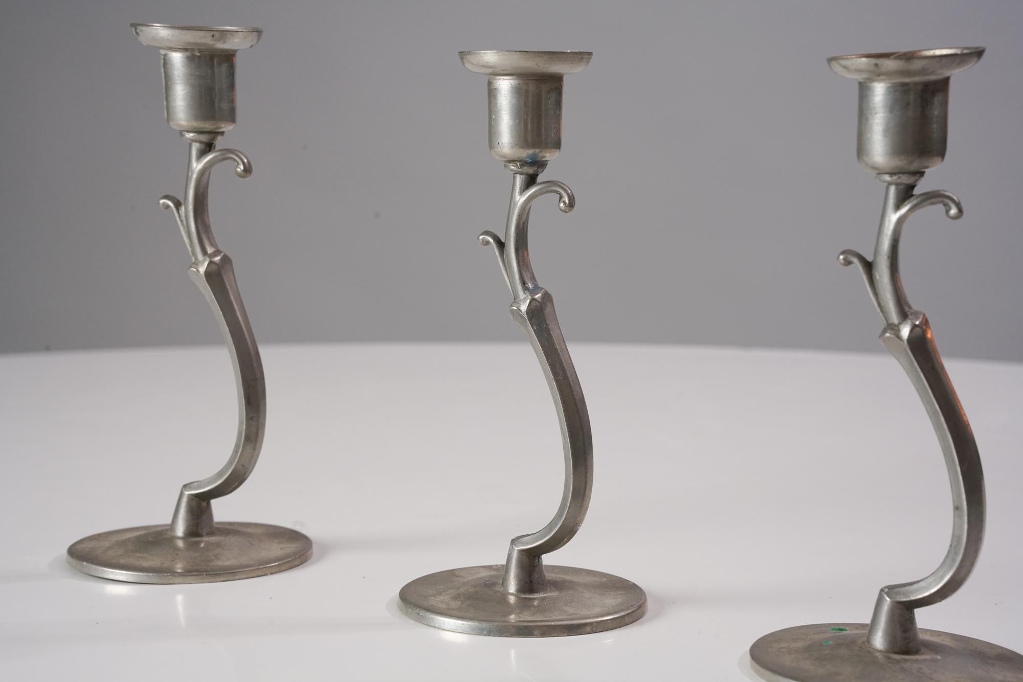 Set of three model 8023 candlesticks by Paavo Tynell for Taito Oy from the 1920/1930s. Tin. Marked on the bottom. Good vintage condition, patina consistent with age and use. The candlesticks are sold as a set. 

Paavo Viljo Tynell was a Finnish
