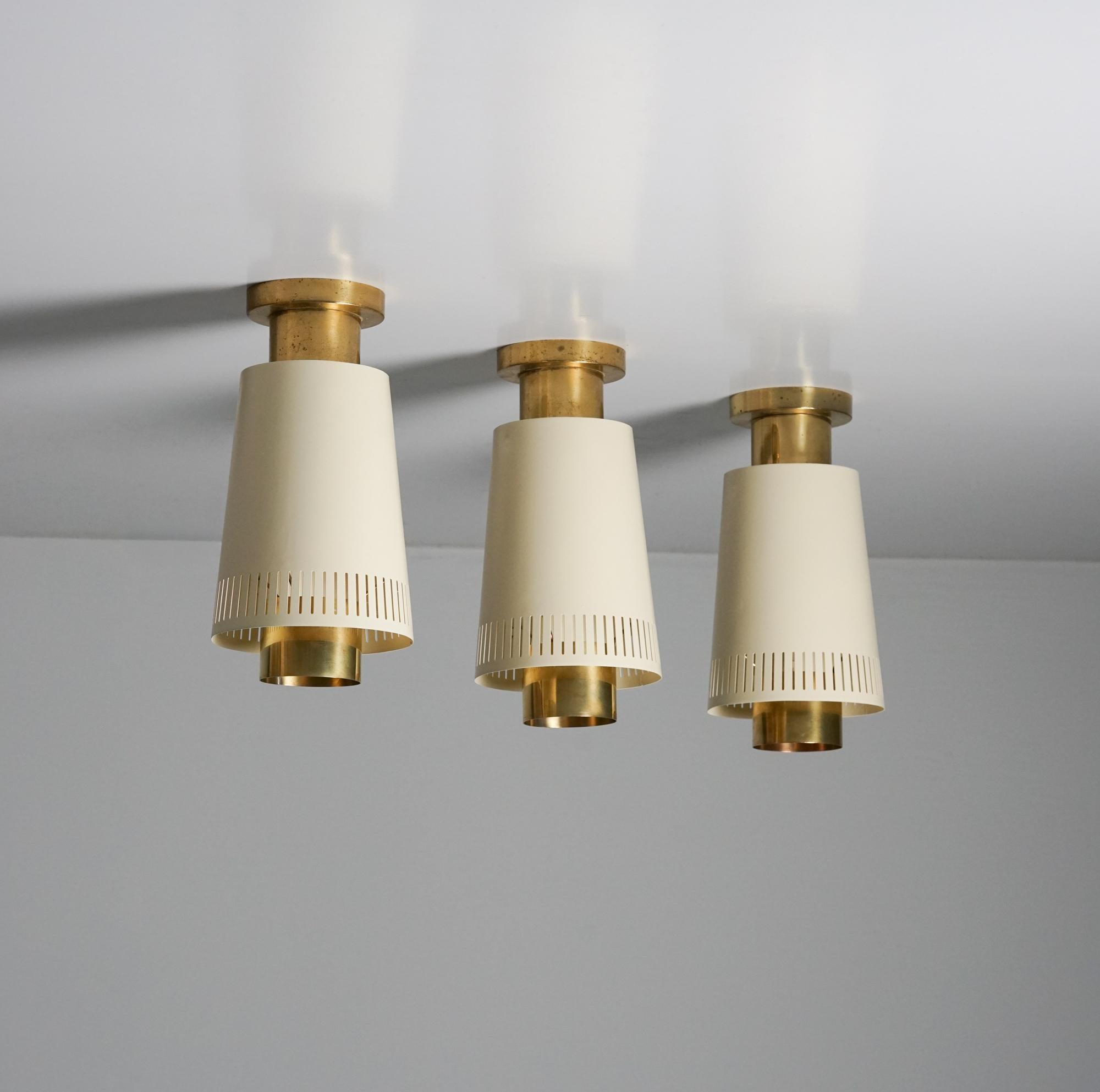 Set of three model 9067 flush mounts, designed by Paavo Tynell, manufactured by Taito Oy, 1950s. Brass and painted metal. Marked. Good vintage condition, minor patina consistent with age and use. 

Paavo Tynell (1890-1973) is one of the most